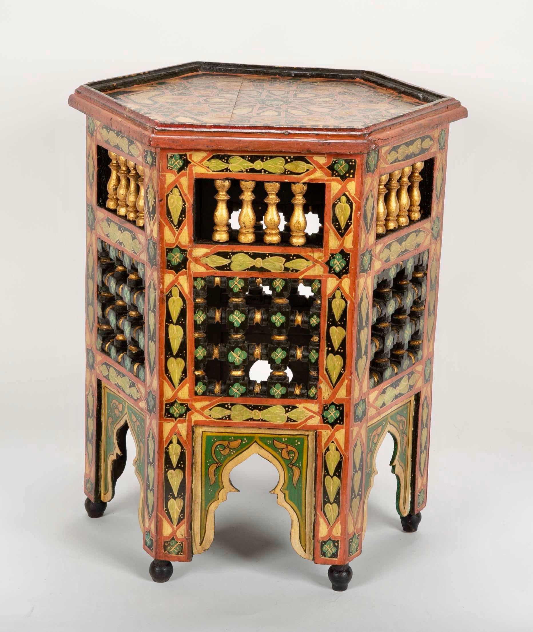 Festive pair of brightly painted and gilt Moroccan hexagonal side tables with intricate turned carving. With green, black, red and gilt surface and Moorish decoration.
