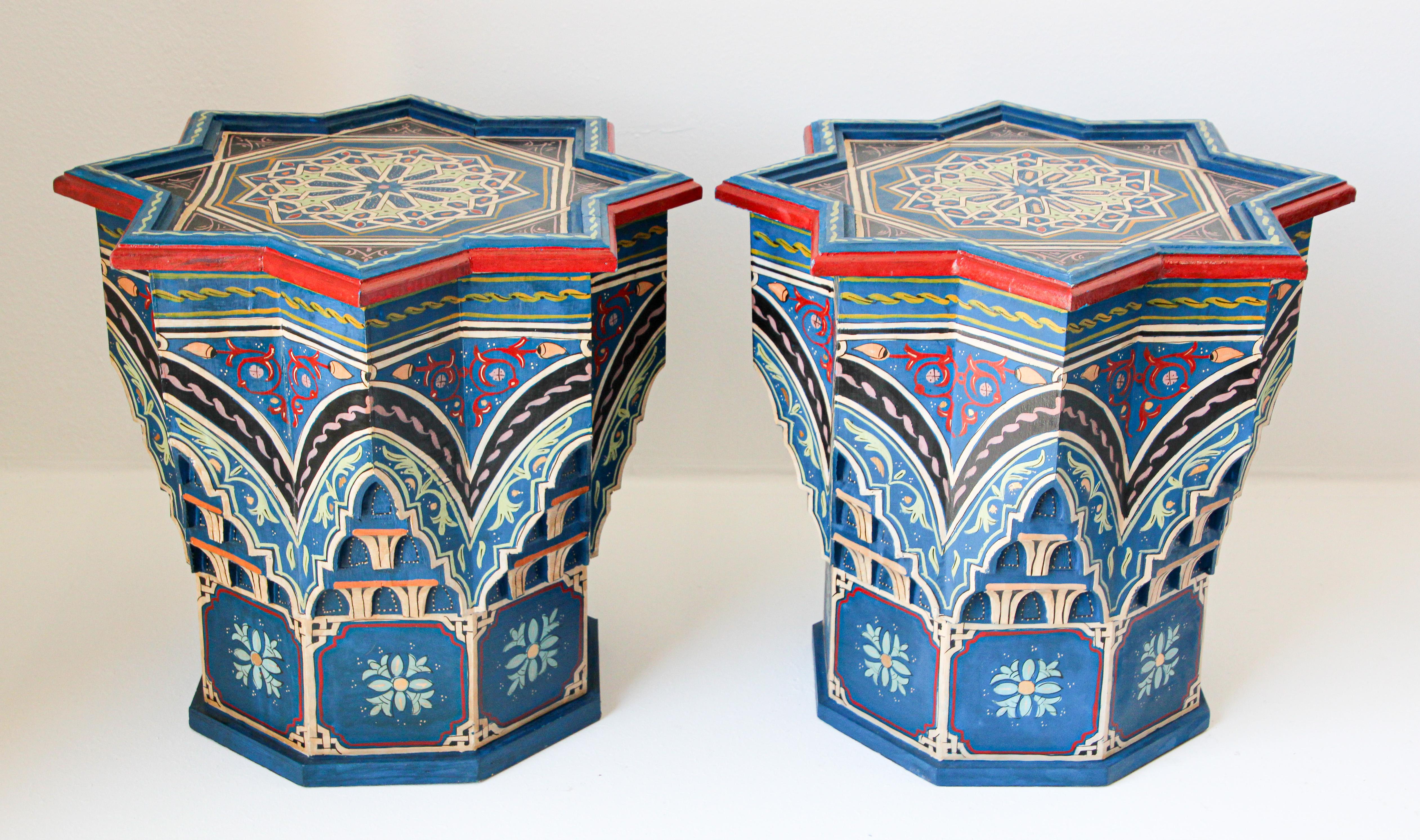 Pair of Moroccan colorful blue hand painted and carved side occasional table with Moorish Islamic designs.
Pedestal tables in royal blue background with multicolored floral and geometric designs.
Very decorative fine artwork on a star shape