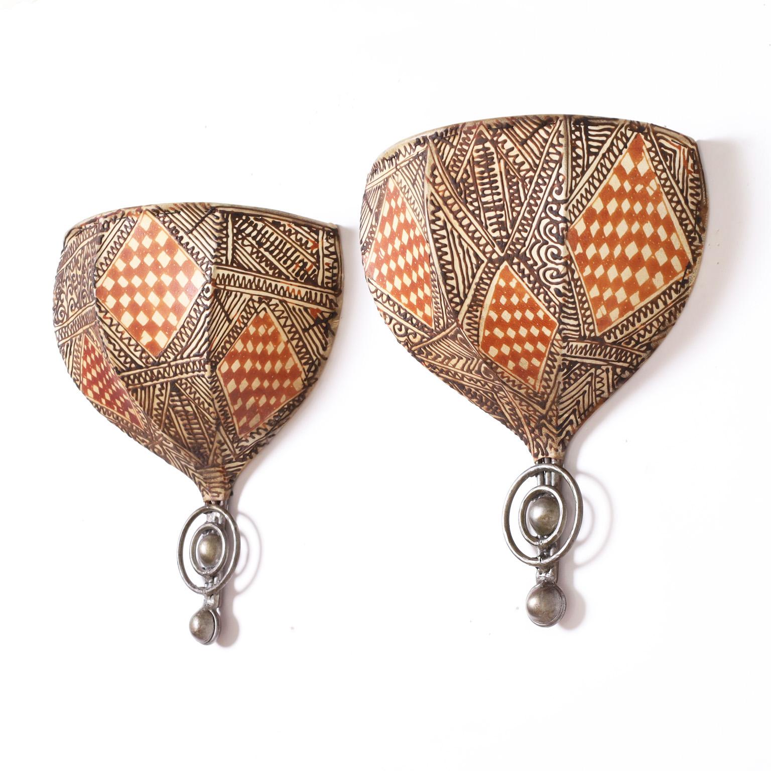 Standout pair of wall sconces handcrafted with metal frames covered in parchment or vellum and paint decorated with floral and geometric mediterranean designs.