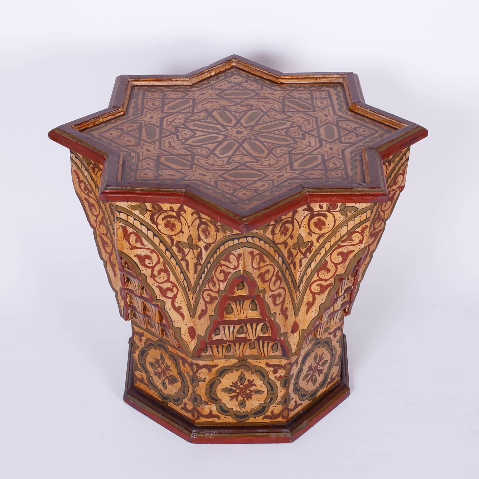 Exotic pair of Moroccan or Moorish painted wood tables or end tables with bold star shaped tops and geometric octagon bases with carved niches and folky symbolic floral decorations throughout.