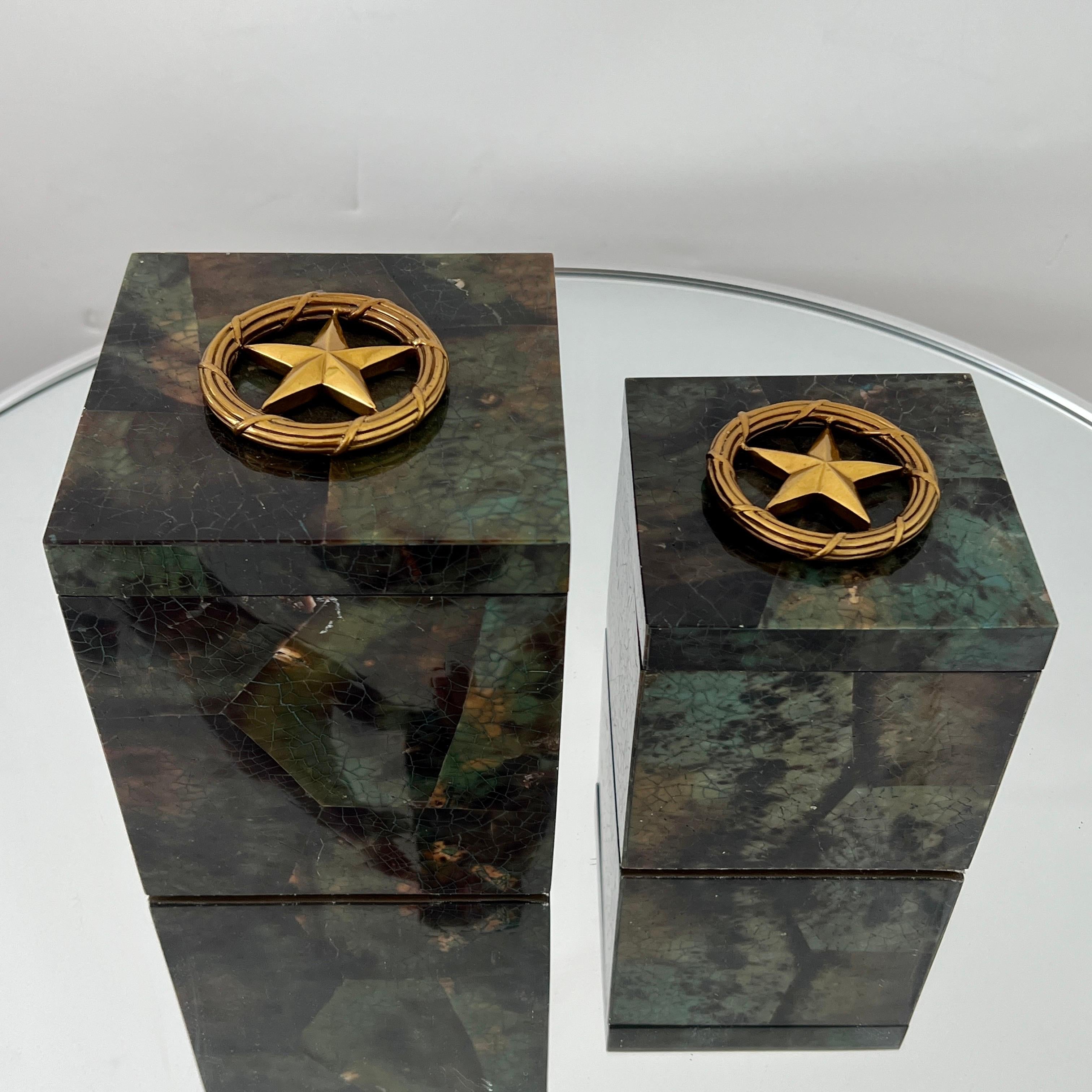 Pair of decorative boxes all handcrafted in exotic materials featuring lacquered and hand dyed pen-shell over a wood frame. The boxes feature mosaic shell inlays in beautiful hues of turquoise, green, black and brown. Fitted with brass stars accents