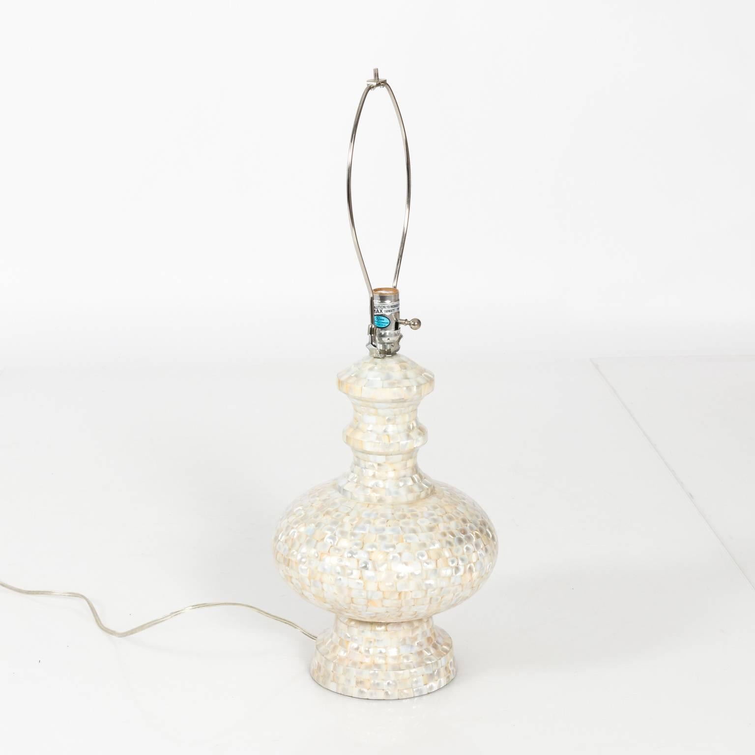 Pair of mother-of-pearl lamps with matching silk shades, circa late 20th century. Note that one lamp is missing a finial.
 