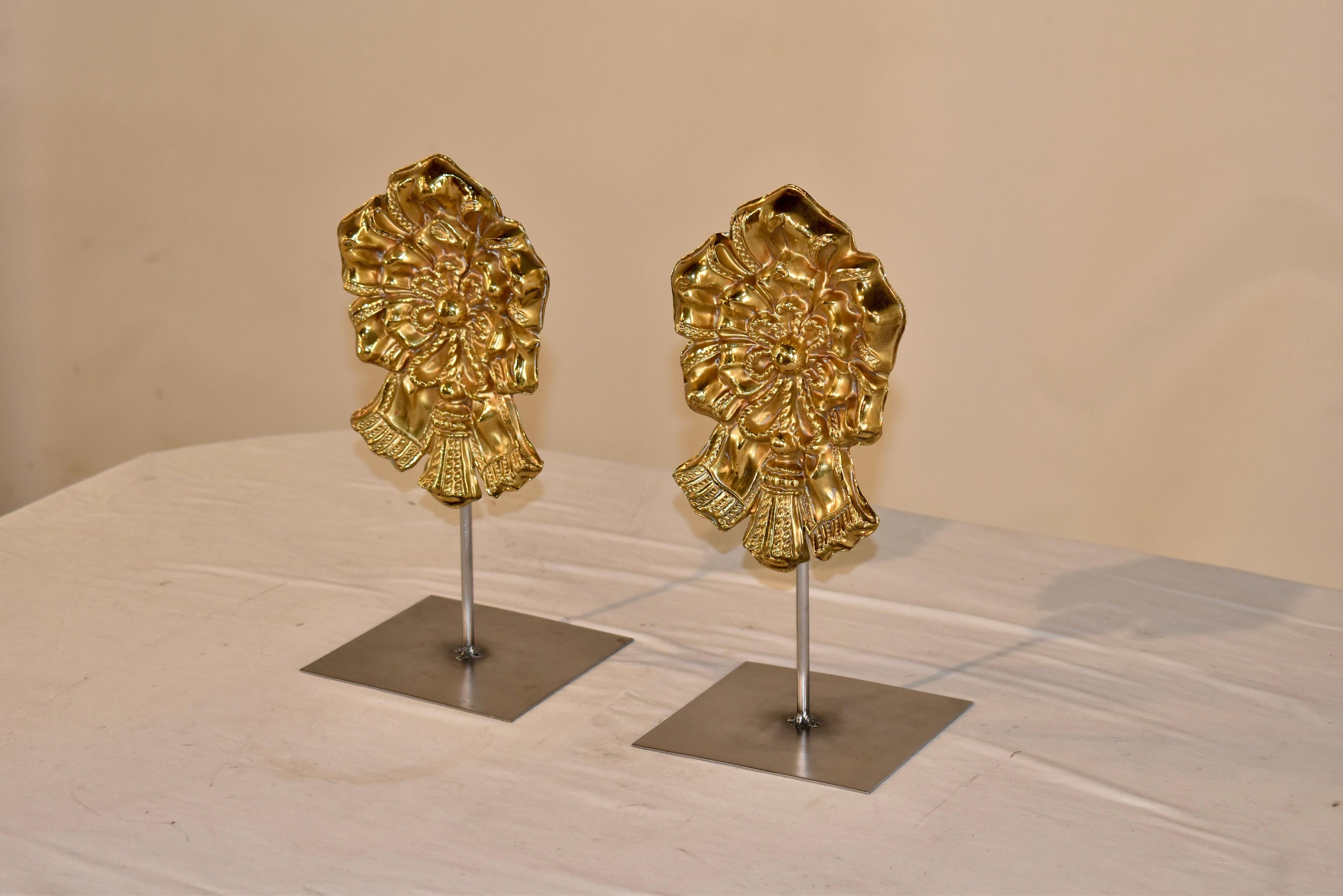 Pair of mounted Georgian decorative brass objects in the form of florals and bows.  The brass was hand stamped and is mounted on modern steel stands, which were custom made by a local artisan.  These are really interesting and would look great on a