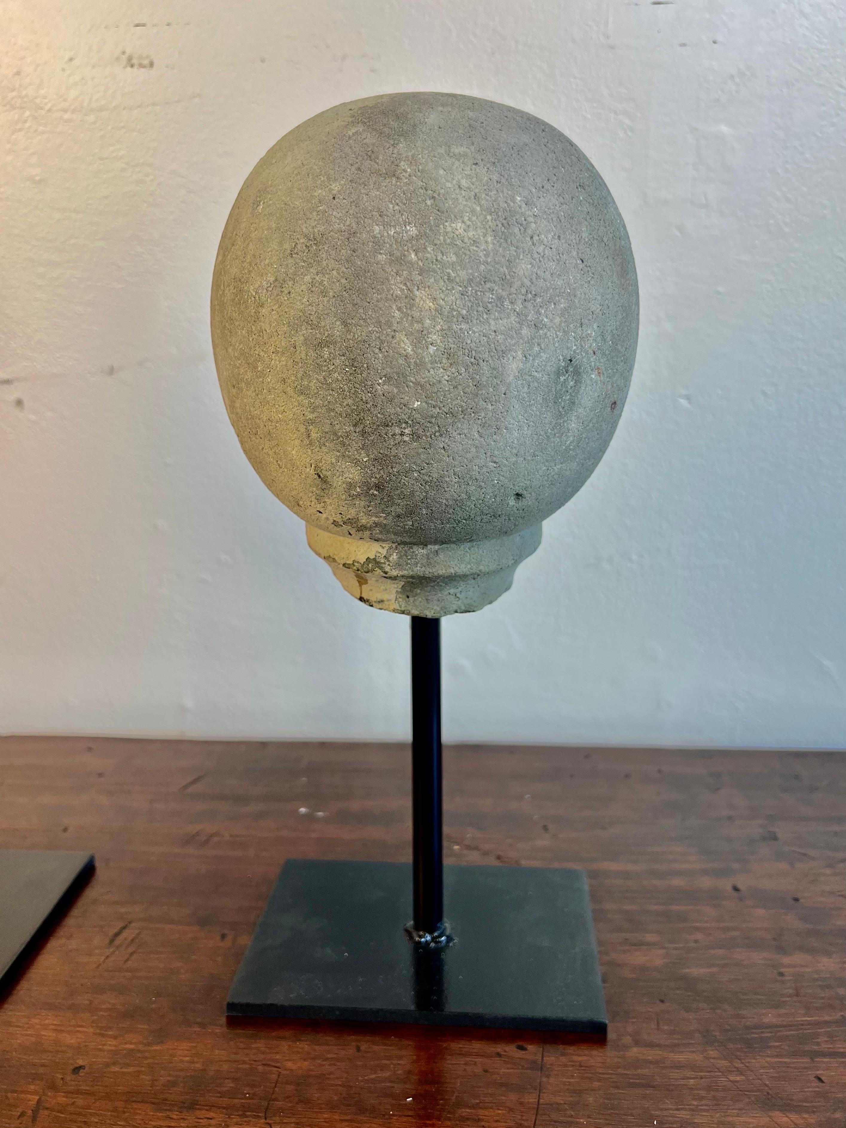 Pair of spheres mounted on iron bases.  One is 19th century and is made of stone.  The second sphere is made of cement and is from the mid 20th century.  They are great accent pieces for a bookshelf or end table.