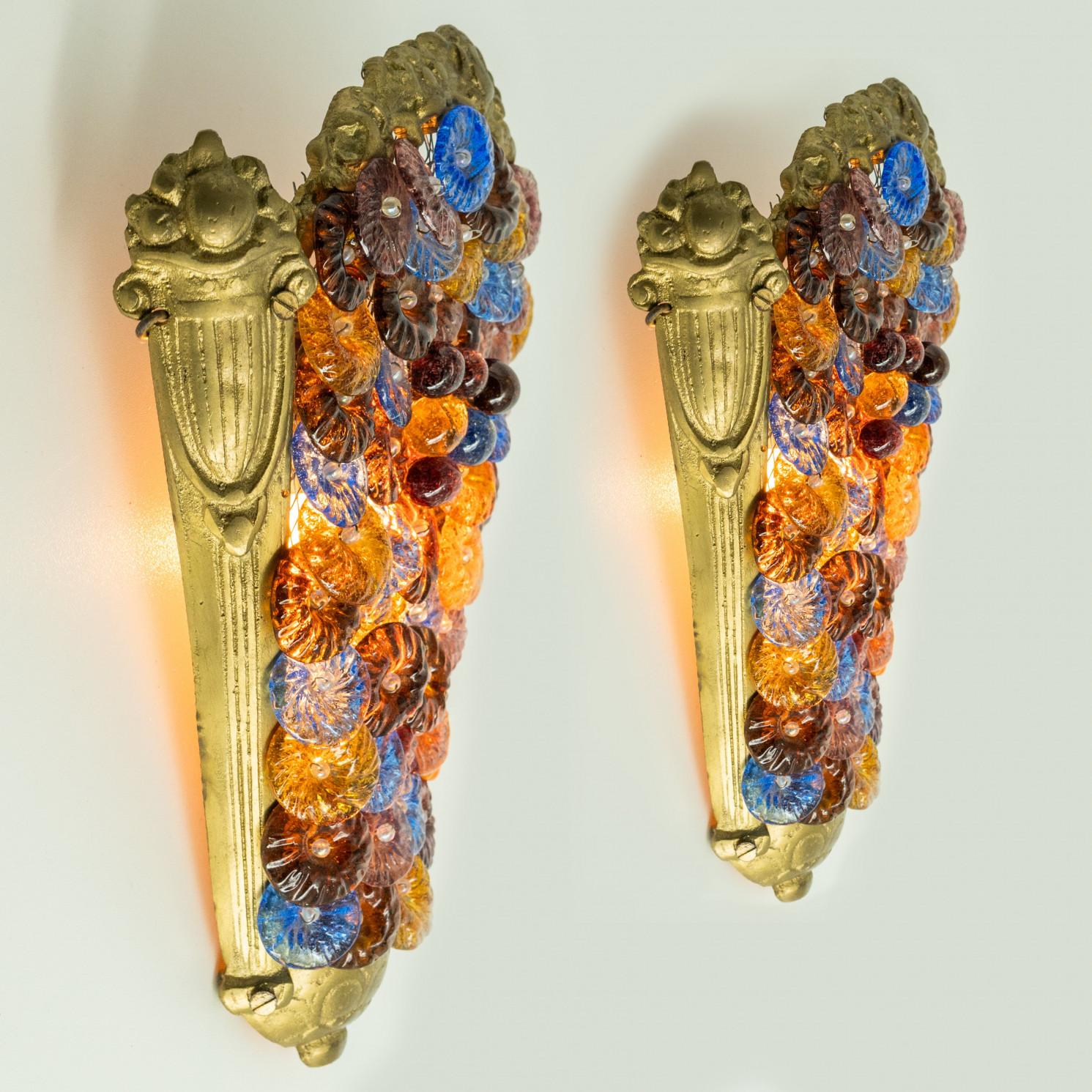 Pair of Elegant multi-color hand-blown Murano glass wall light, Italy. Manufactured around 1960.

This Murano glass wall light casts a warm, colorful glow as light filters through its amber, blue, and brown glass flowers, creating a vibrant, elegant