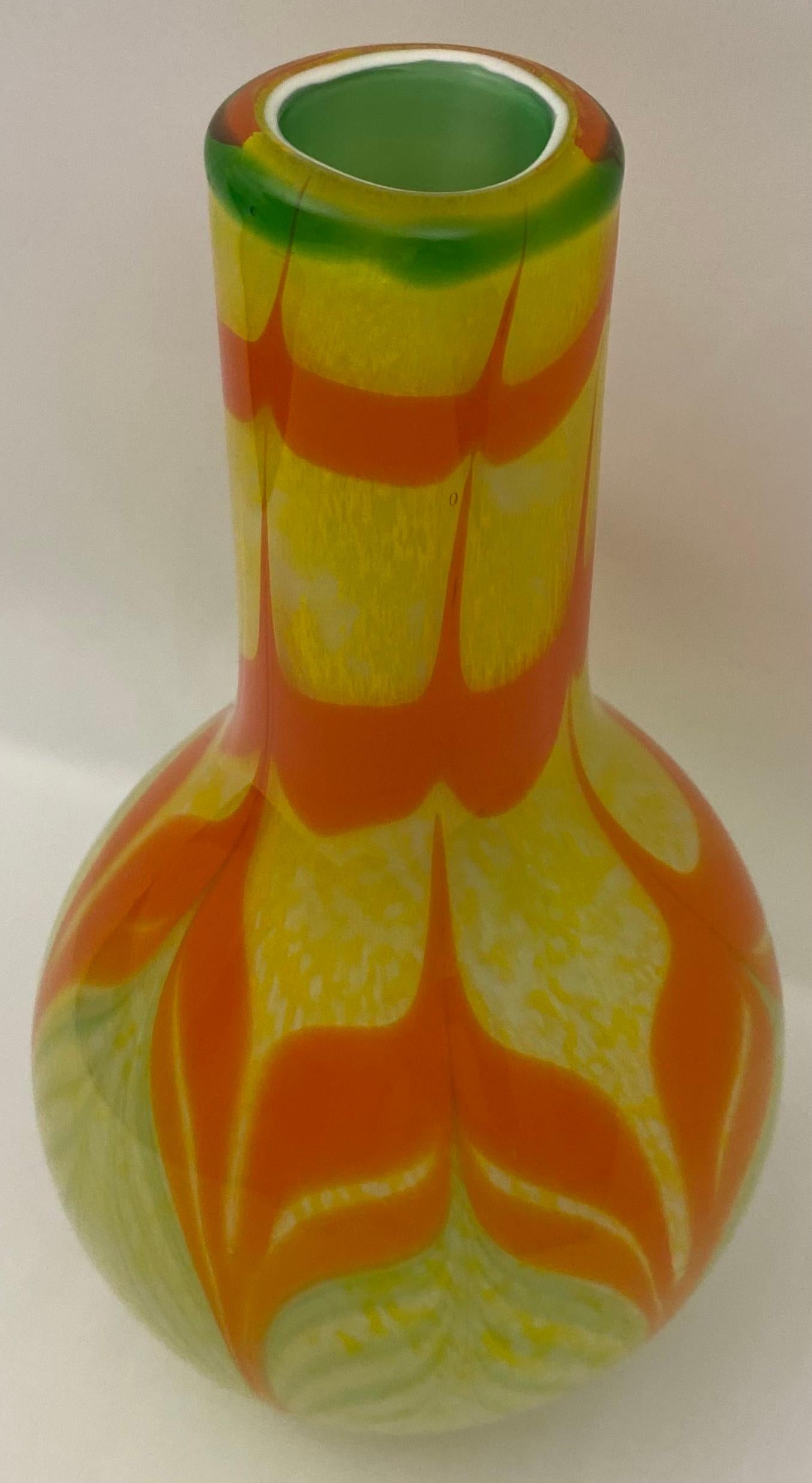 A wonderful pair of Murano art glass vases screaming to be displayed. 
Round in form with a tapered base, and balloons out at the middle and cinches in at the top.

Tall strokes of deep orange and with green accentuating the vessels throughout on a