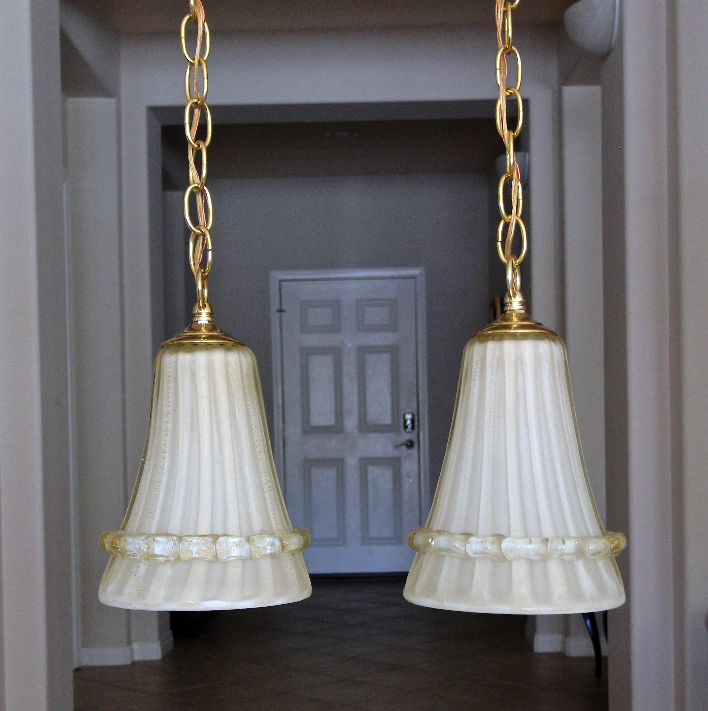 Pair of Italian handblown glass cream colored with gold inclusions ceiling pendants lights. Each suspended on brass chain and ceiling. Newly wired with all new brass fittings, each uses single candelabra size bulb. Size of pendant 9