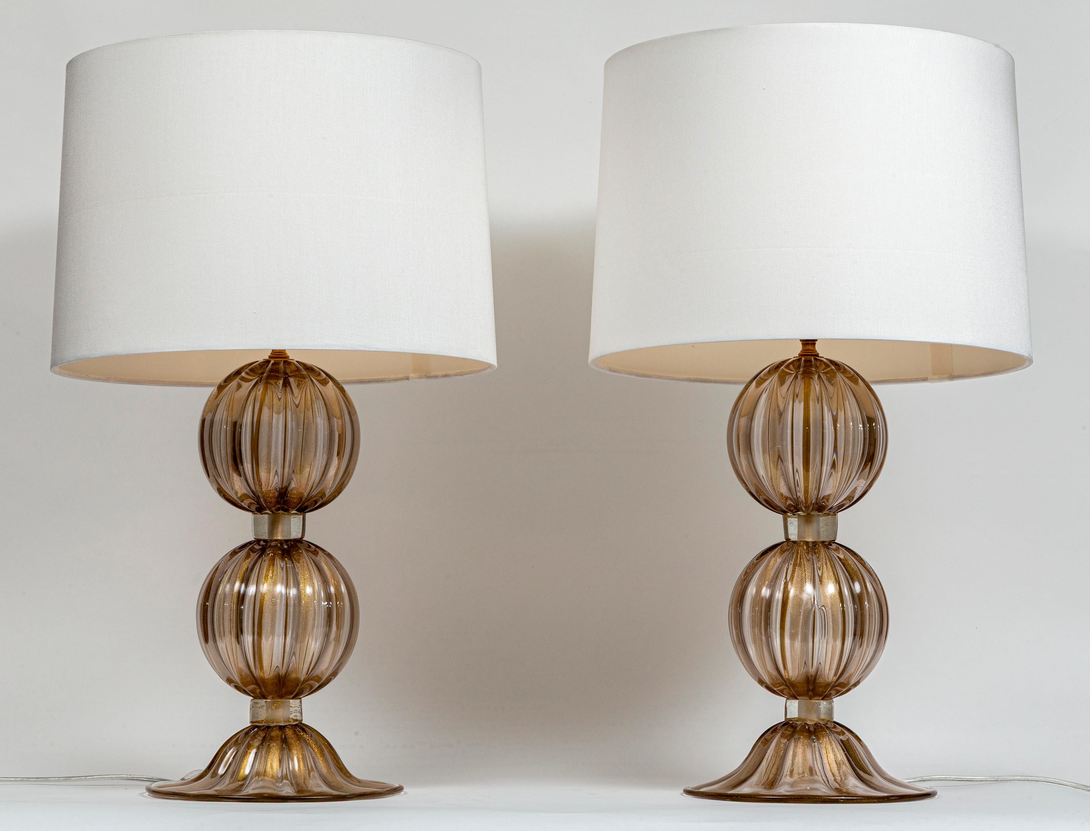 Preciosa pareja de lámparas compuesta por  grande  Bolas de caña sopladas de oro de 23 quilates que terminan en una elegante base en forma de cúpula.

Iluminado con bombilla E26 con LED cálidos.

Origen: Murano, Italia

Dimensiones del cristal: 10″