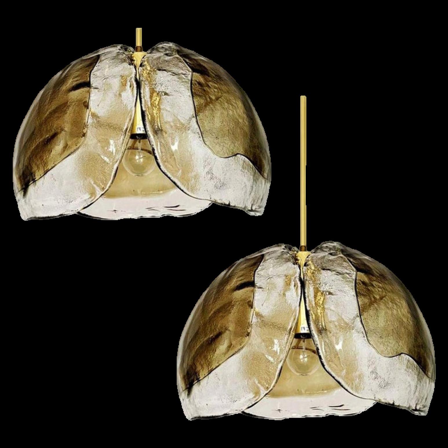 Une paire de très belles lampes suspendues fabriquées au milieu du siècle, vers 1970. Trois verres de Murano aux tons fumés ou ambrés sont montés sur un luminaire en laiton. Livraison avec chaîne de minerai à barres.

Les feuilles de cristal