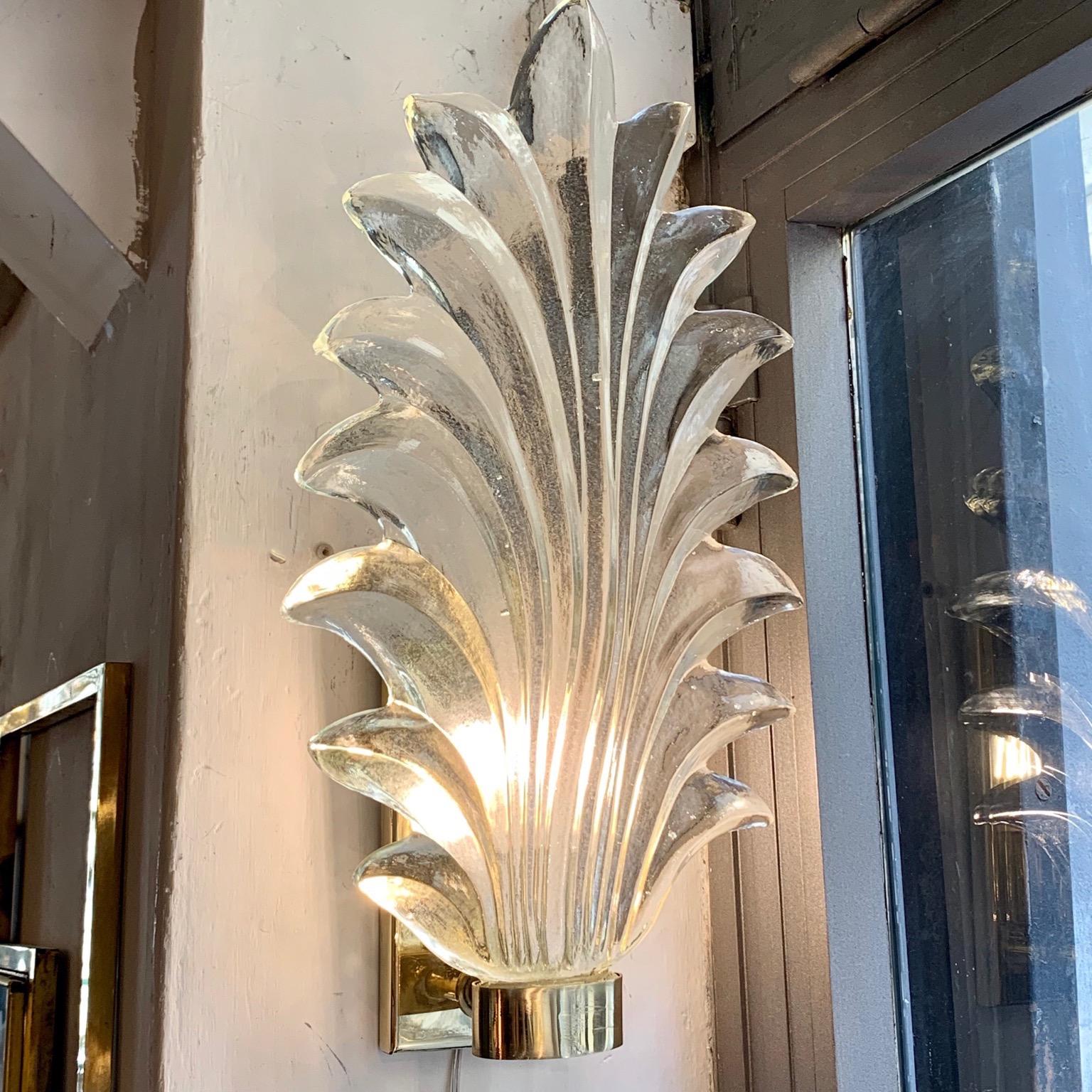 Pair of Murano clear glass leaf sconces, brass structure, one bulb per sconce.
The hand blown bright clear glass is thick and heavy.