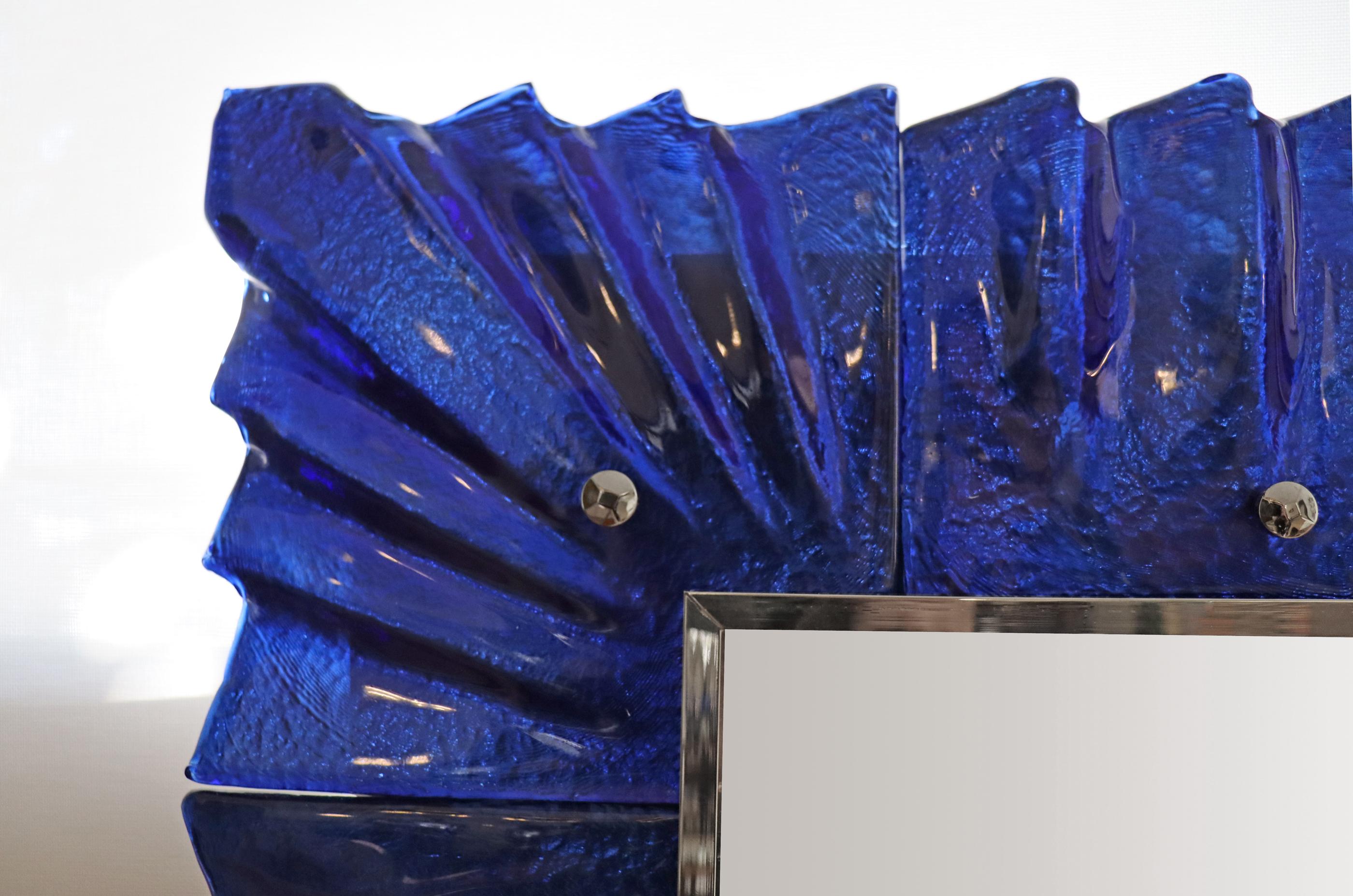 Paire de miroir en verre bleu cobalt de Murano, en stock
Accents en cabochon plaqué nickel.
La texture et la couleur du verre sont absolument saisissantes.
Galerie périphérique nickelée
Peut être accroché verticalement ou horizontalement.
Paire