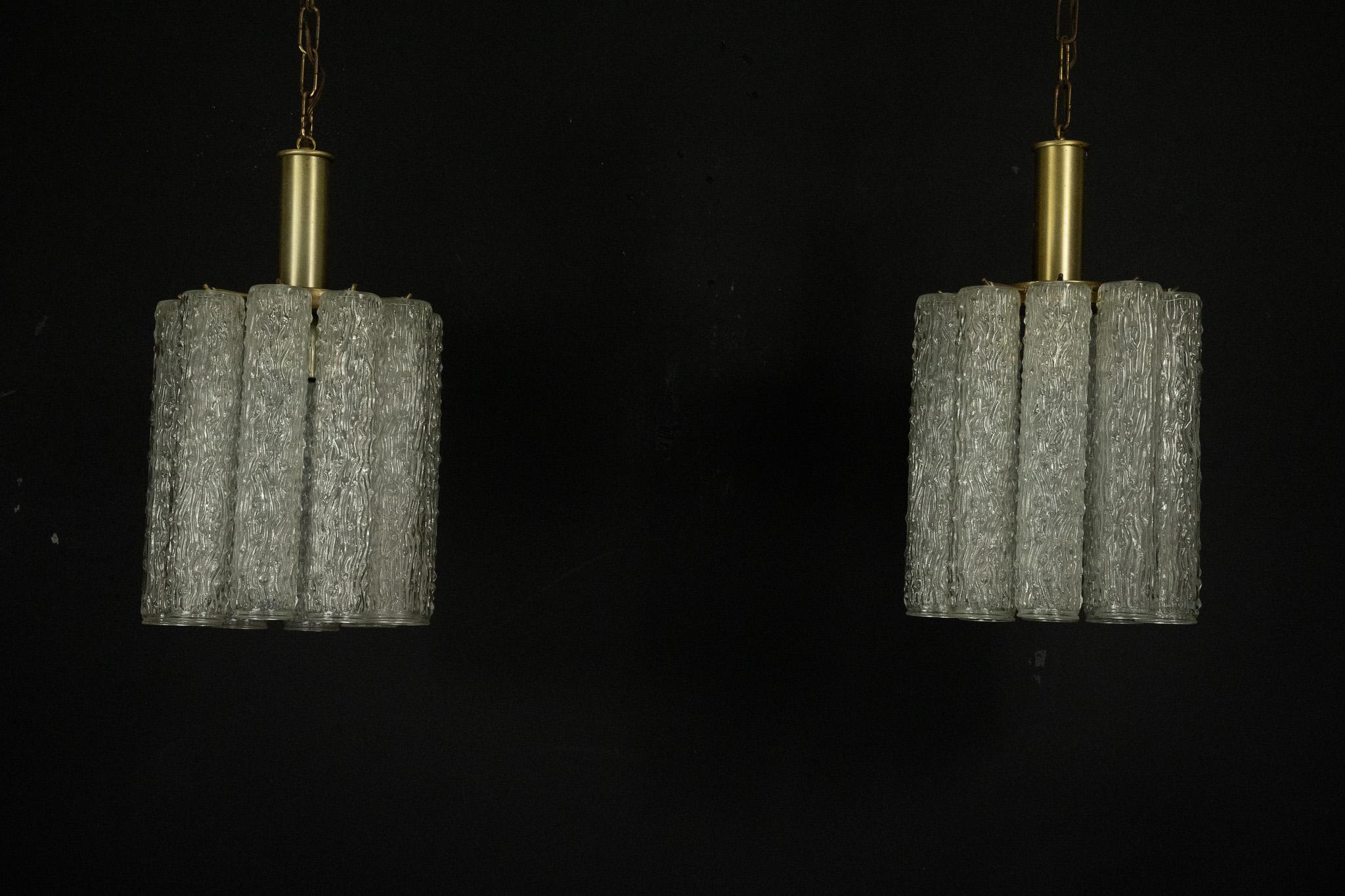 Elegante coppia di lampadari in vetro di Murano e ottone, ispirati allo stile distintivo di Toni Zuccheri, realizzati in Italia negli anni Settanta. Ogni lampadario presenta una raffinata combinazione di elementi in vetro di Murano e dettagli in