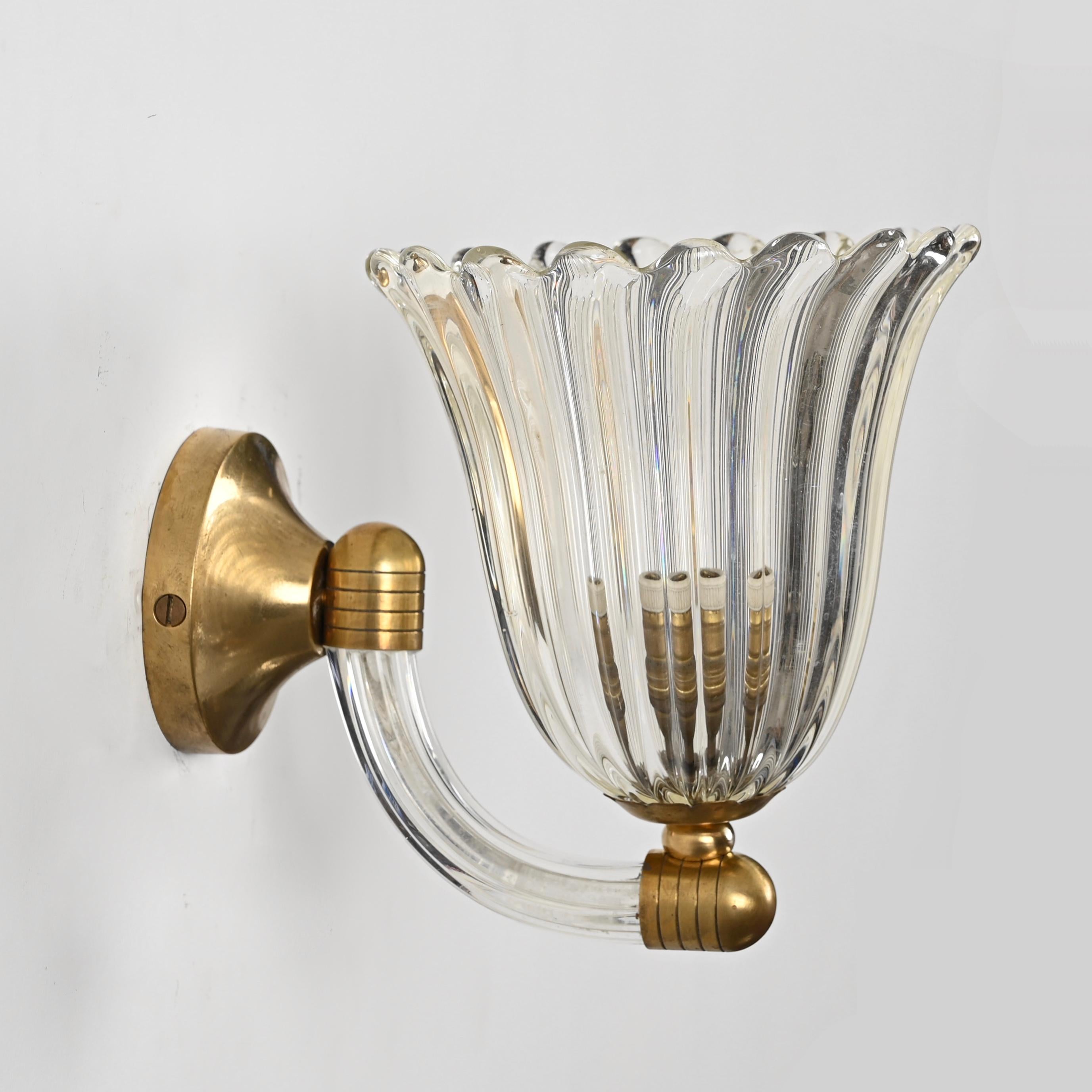 Spectacular pair of mid-century bellflower shaped sconces in Murano hand-blown crystal glass and solid brass. These wonderful lights were designed in Italy by Barovier & Toso in the 1950s.

These finely crafted Murano sconces have a magnificent