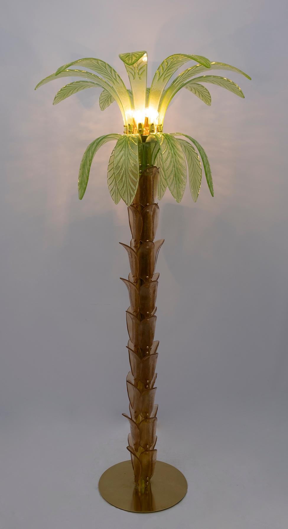 Paire de lampadaires en verre soufflé de Murano ambre et vert, structure en laiton, quatre ampoules.
Le lampadaire est également une sculpture qui reproduit le tronc et les feuilles d'un palmier avec des morceaux de verre.
Recâblage avec une prise