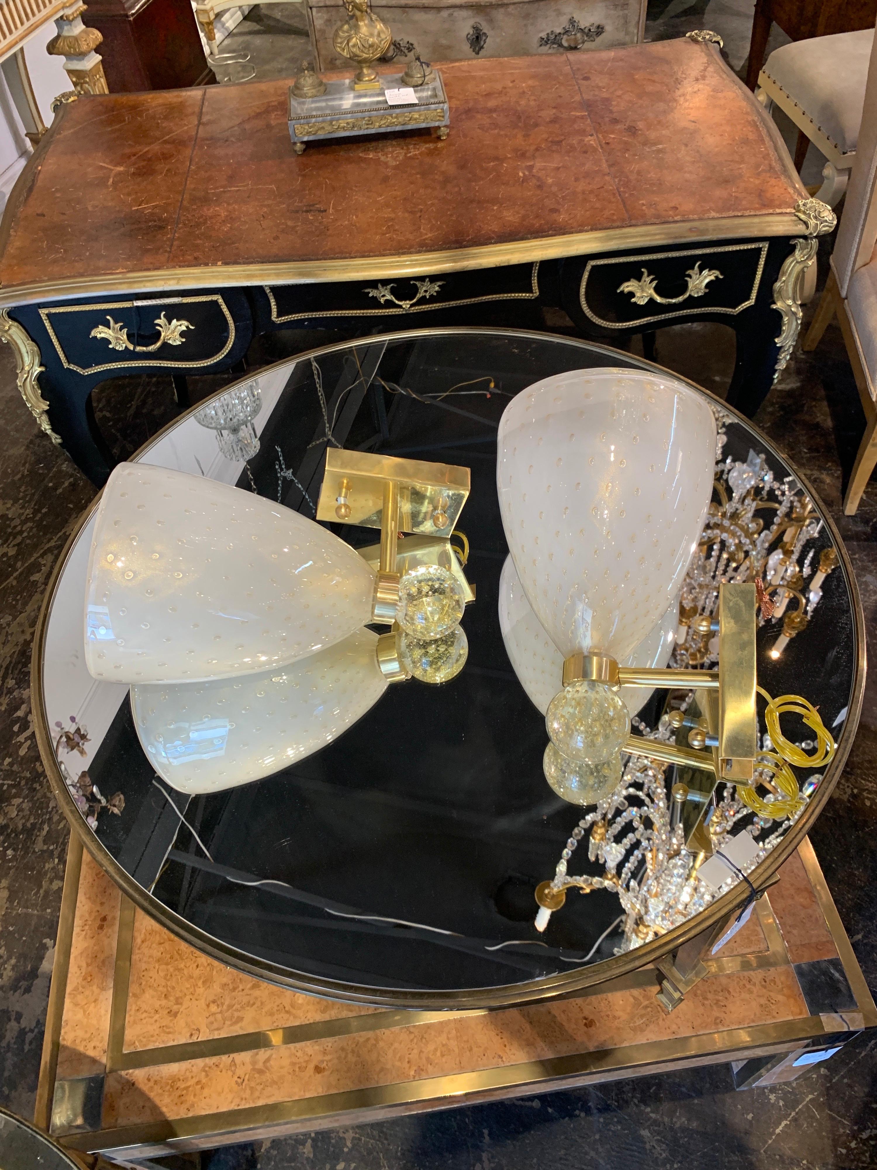 Elegant pair of single light Murano glass and brass sconces. Beautiful translucent glass with gold details with substantial decorative brass bases. A very fine pair!