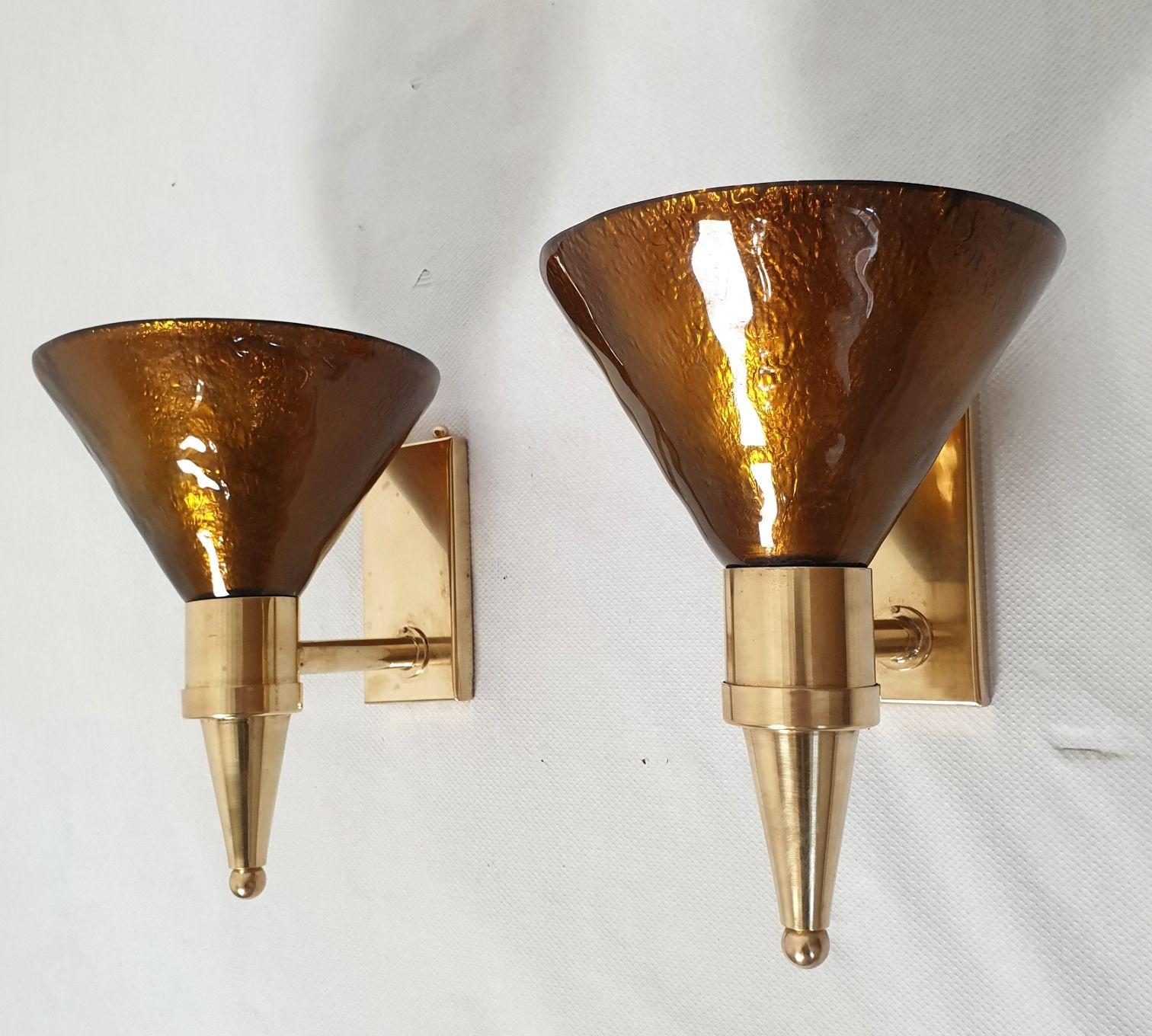 Pair of Mid Century Modern Murano glass and brass sconces, Attributed to Sciolari, Italy 1970s.
The vintage sconces are made of a thick Murano glass cone, nesting the light and brass mounts.
The Murano glass is mirrored, in a warm dark caramel