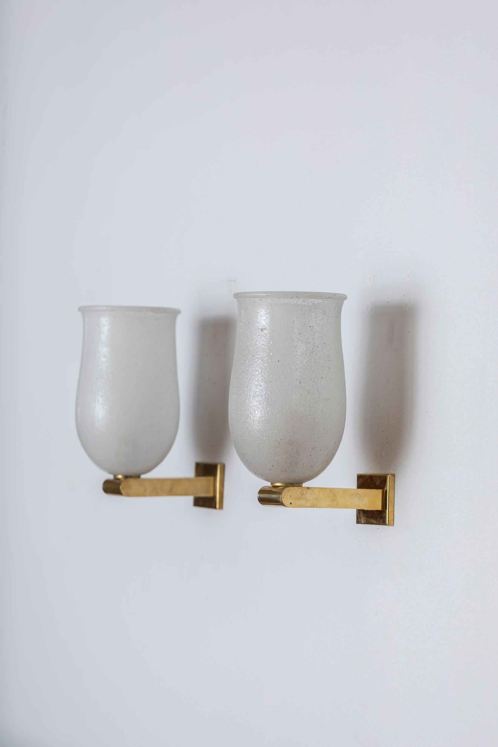 Pair of elegant wall lights in pulegoso Murano glass, supported by golden brass structure, elegantly finished. 
Tipical pulegoso glass details. 
Italy, 1970.
 