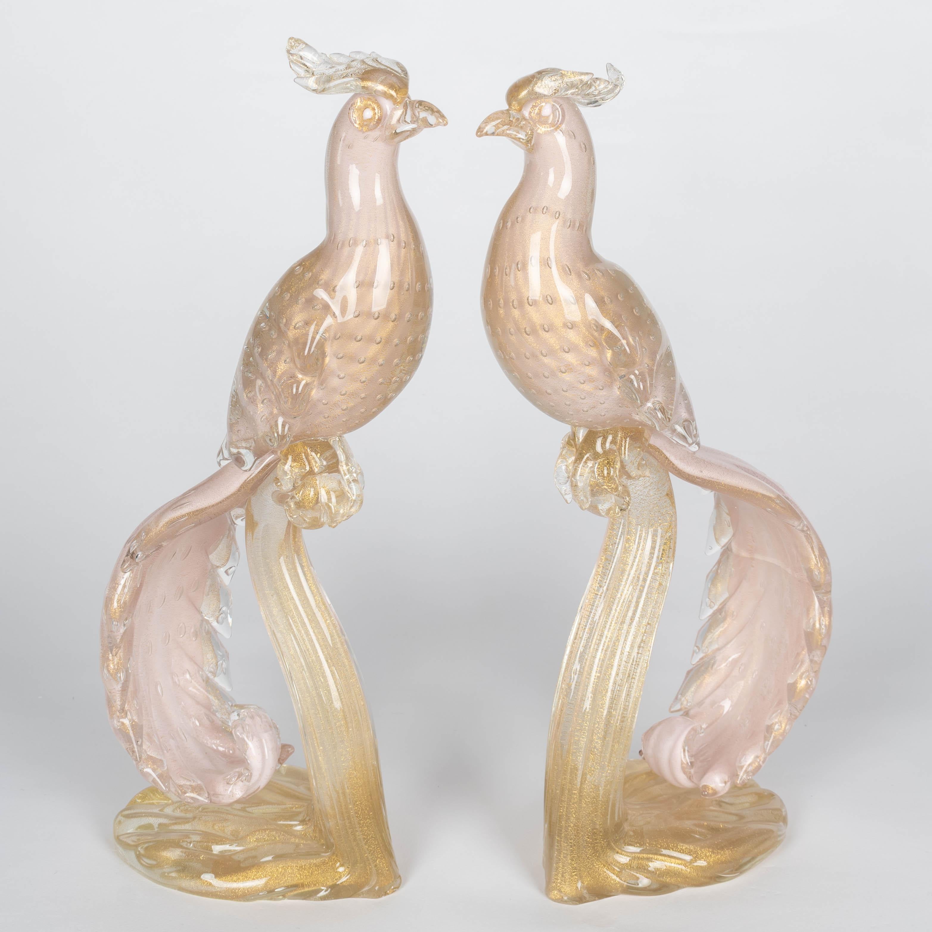 A pair of Mid-Century Murano handblown glass Birds-of-Paradise, by Alfredo Barbini. Beautiful pale pink color with gold inclusions throughout and controlled bubbles on the body and tail. Each bird has tall, elegant curving form with curl of the tail