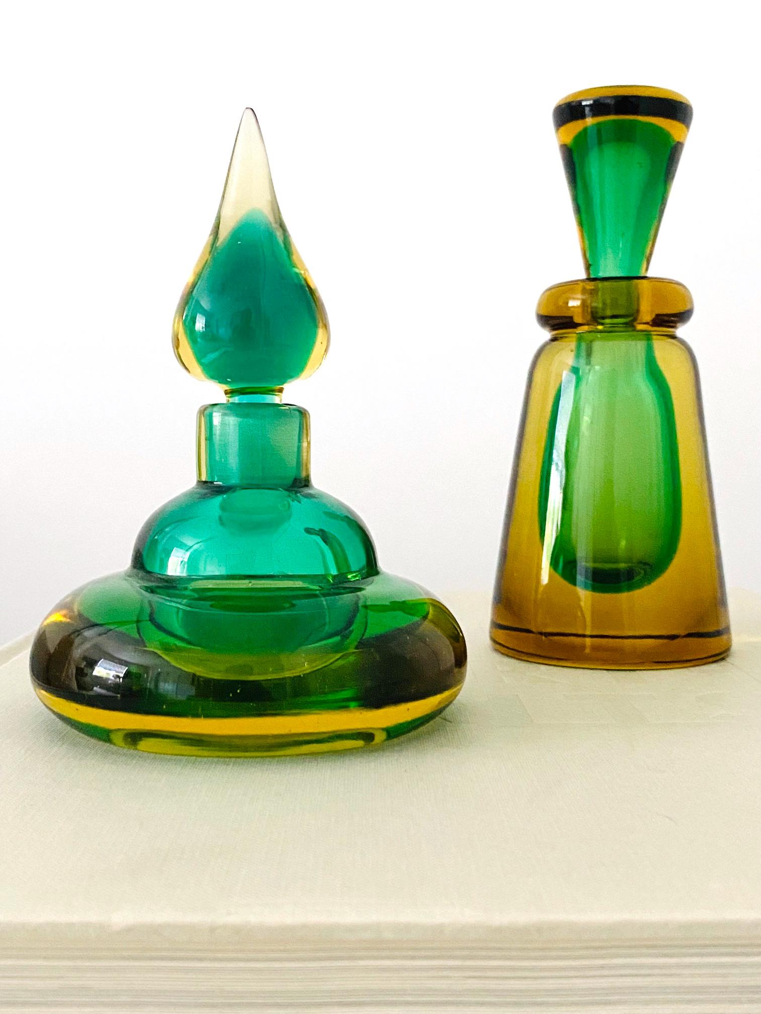 Mid-Century Modern decorative bottles or vintage perfume bottles by Flavio Poli for Seguso. Beautifully handcrafted in vibrant hues of emerald green and golden yellow. Hand blown glass with Sommerso technique. One features a stylized genie bottle