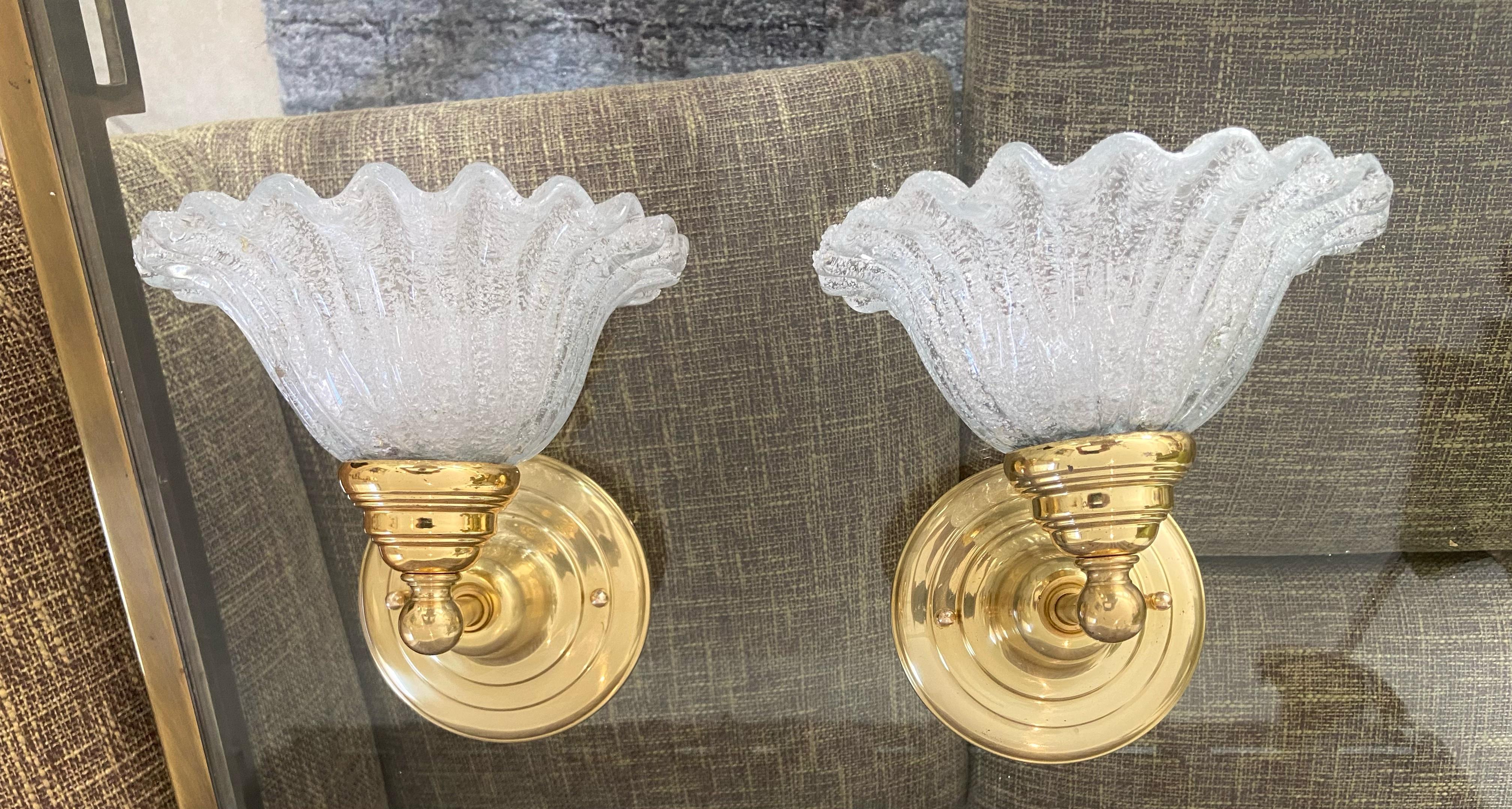 Pair of hand blown Italian Murano clear textured glass wall sconces, supported on brass backplates. Reverse side of the leaf in the 