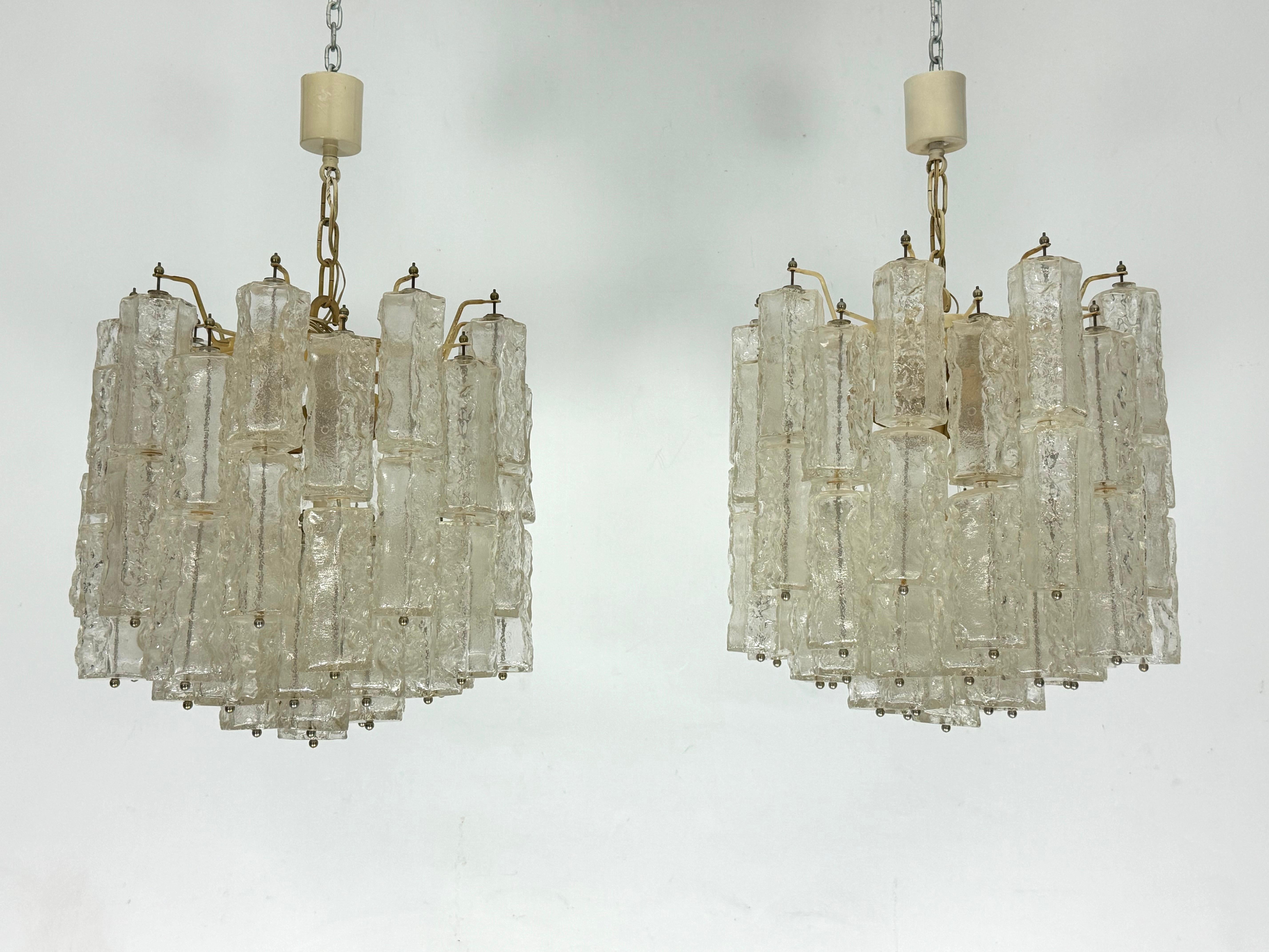 Rare Set of two Murano glass chandeliers produced by Venini during the 70s.
Good vintage condition with normal trace of age and use on the metal structure. All glasses with no cracks or chips. Full working with EU standard, adaptable on demand for