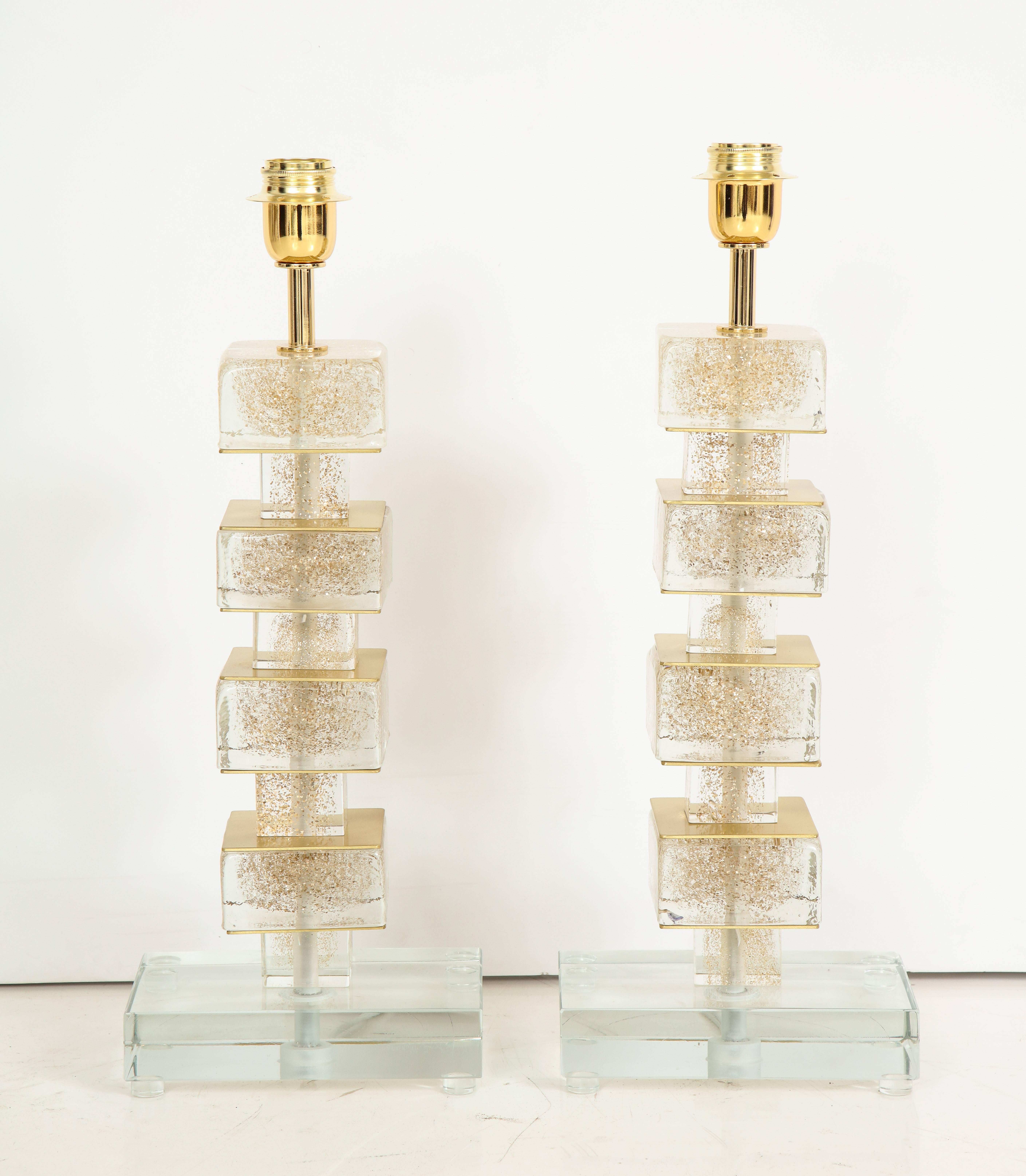 One of a kind pair of hand-casted and handcrafted Murano glass and brass lamps in clear glass infused with 24-karat gold flecks. Individual glass blocks are separated by brass plates and sit atop a solid clear Murano glass block base. Signed by the