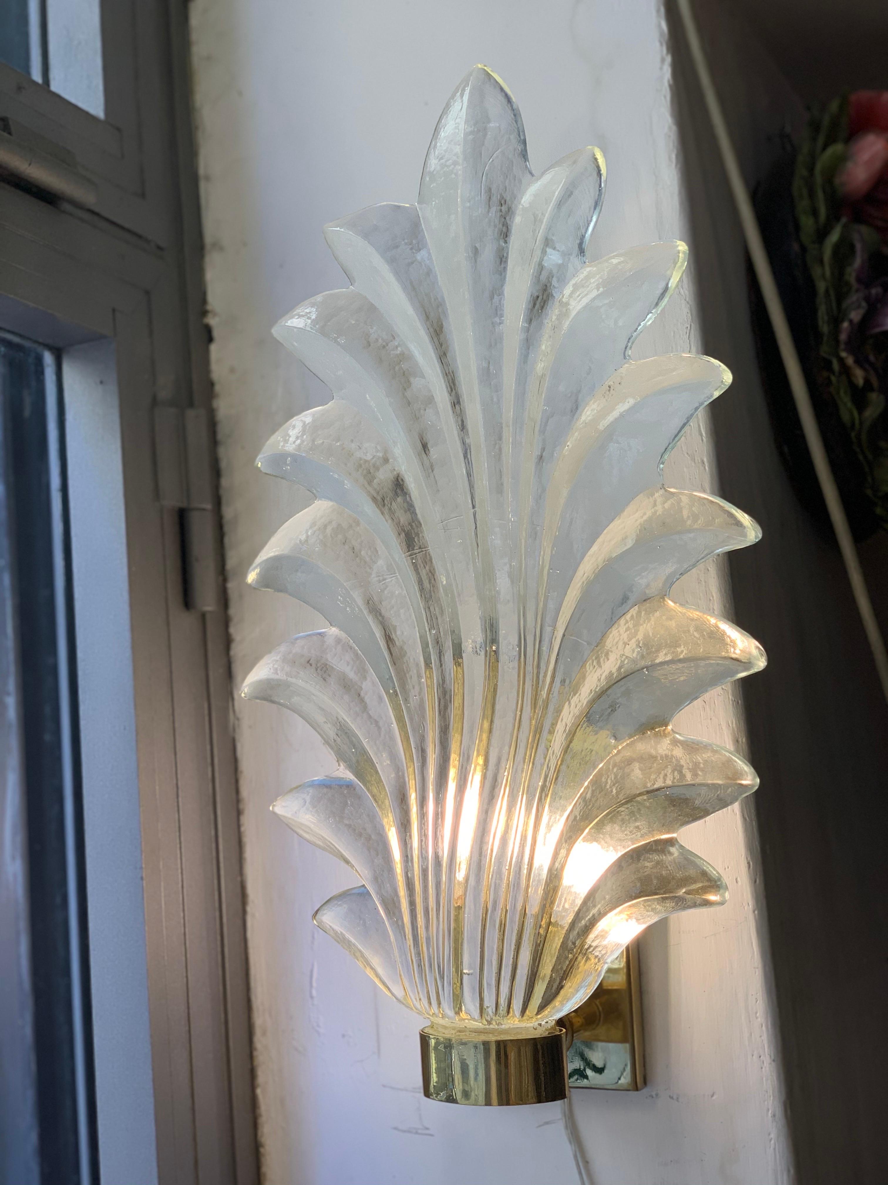Pair of  Late Art Deco Clear Murano glass leaf sconces, brass structure, one bulb each lamp. These sconces are in Murano hand blown thick clear glass.