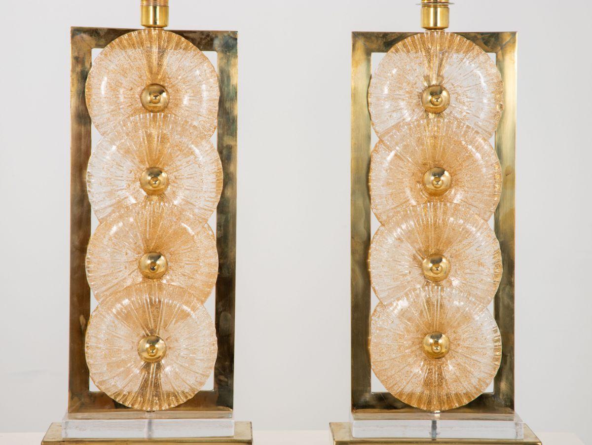 A pair of pressed glass Murano lamps. Pressed glass has gold flecks to throw a beautiful light. Glass is mounted in a brass frame and has repalced plugs for American outlets. Some wear to brass. Shade not included.
