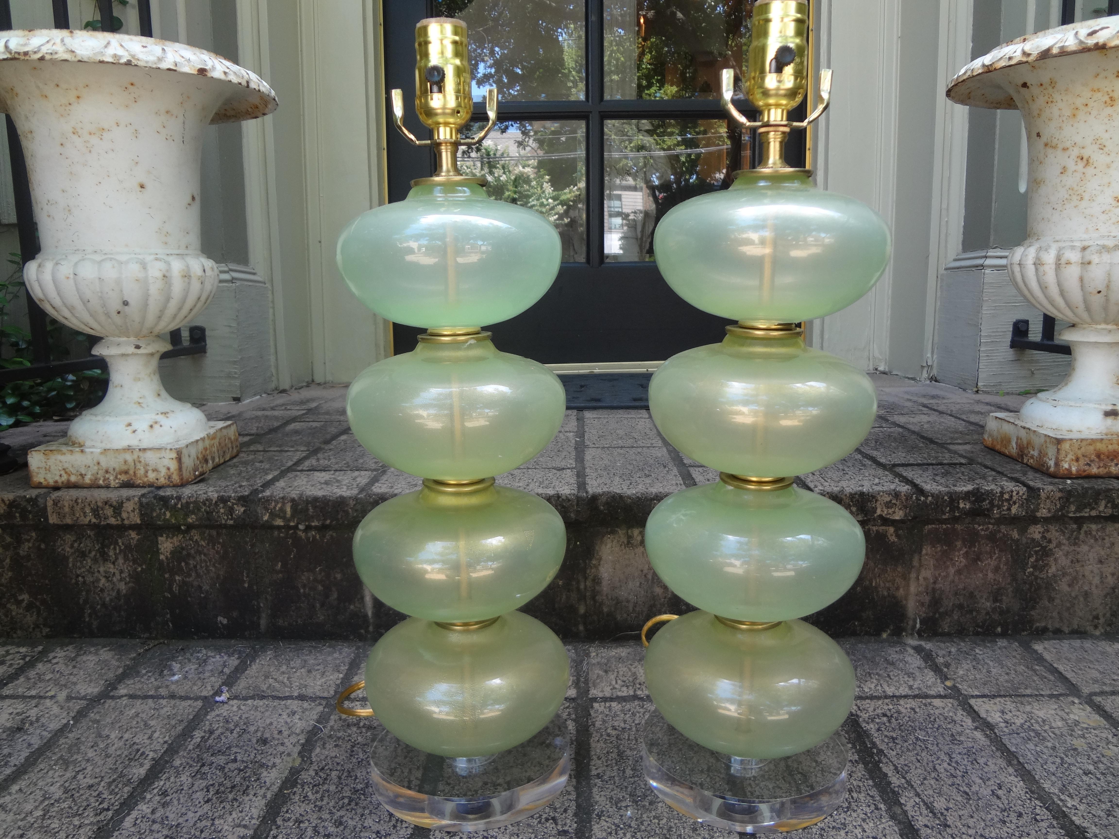 Fabulous pair of Mid-Century Murano glass lamps in celadon green or sea foam green with gold inclusions. These stunning Hollywood Regency murano glass stacked ball or stacked sphere lamps are comprised of 4 large glass spheres and brass accents