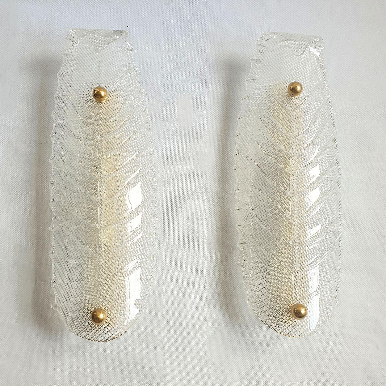 Paire de grandes appliques en verre de Murano, attribuées à Vistosi, Italie, années 1970.
Les appliques vintage ont une forme de feuille stylisée, dans un verre transparent texturé soufflé à la main à Murano.
Le cadre de l'applique italienne est en