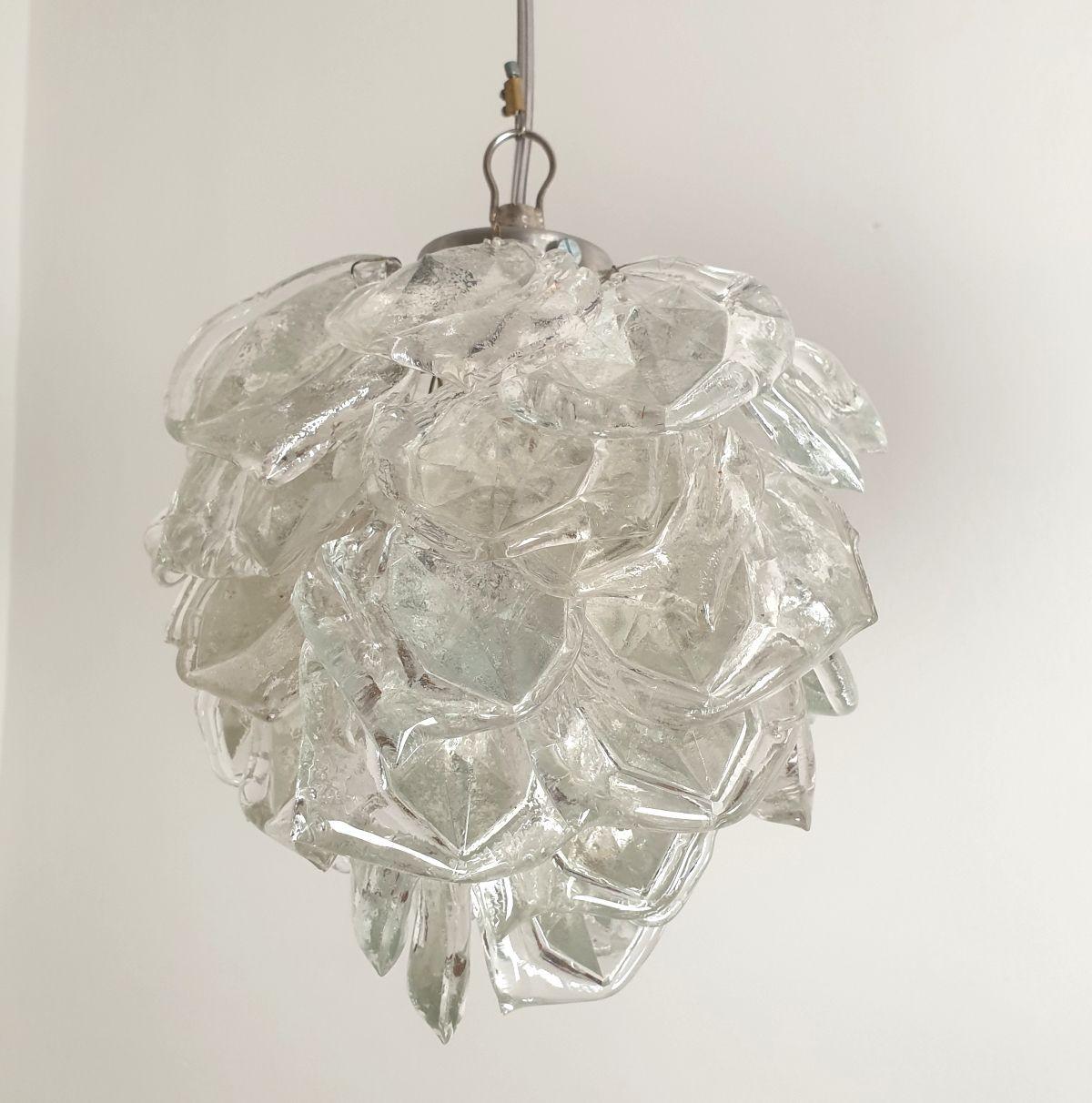 Paire de lampes suspendues en verre taillé de Murano, style Mazzega, Italie vers les années 1970.
Vendu et tarifé par paire. Jeu de quatre pendentifs disponible.
Les pendentifs sont constitués d'éléments en verre de Murano taillés dont la forme