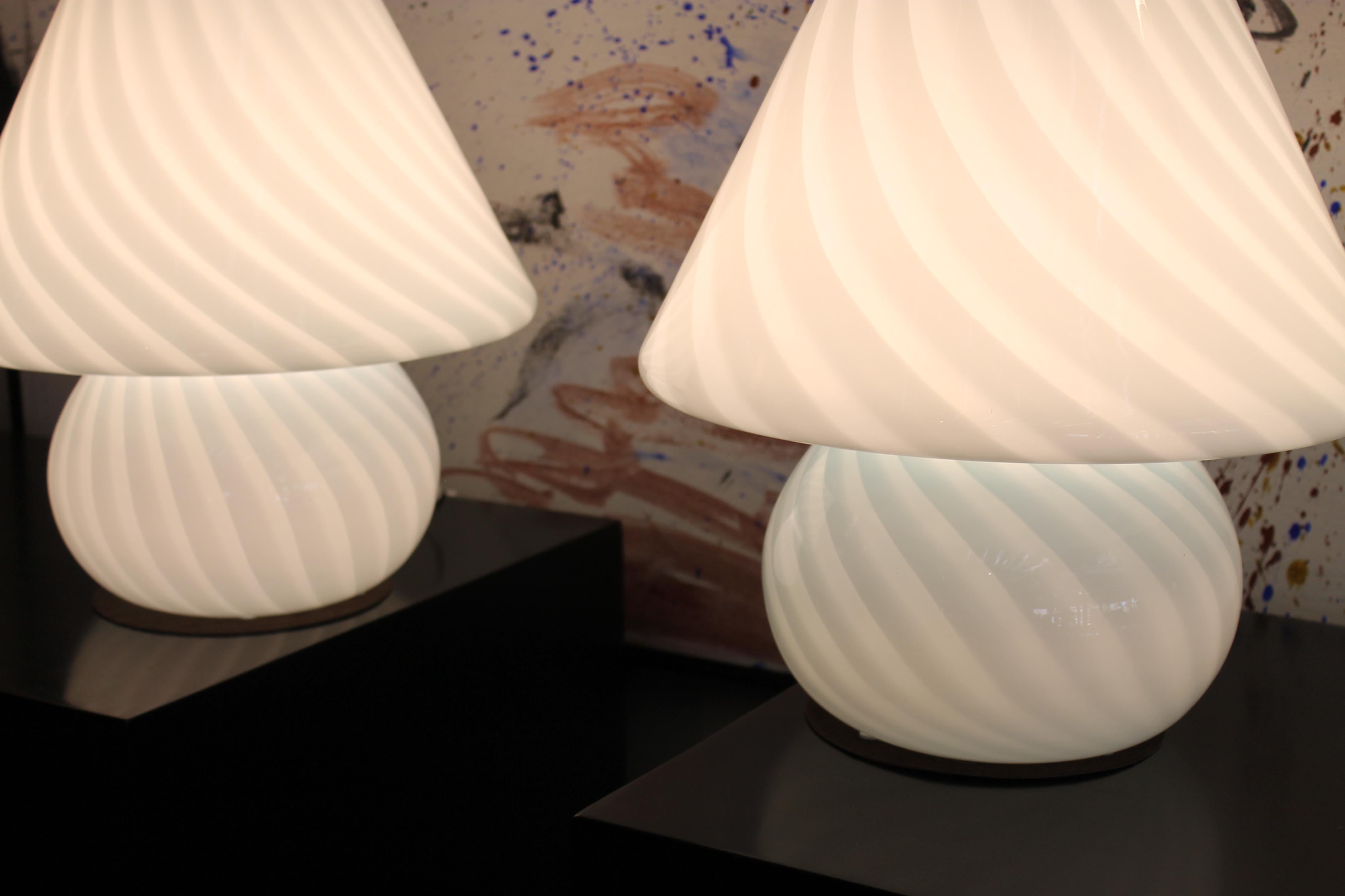 Pair of Italian white or blueish glass mushroom lamps. Each lamp measure 14” diameter and 15” high. These are the LARGER versions. They have been professionally rewired and have an on/off switch. Maximum wattage would be a 60 watt bulb.  Please note