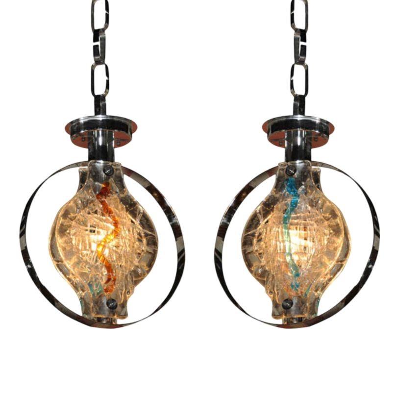 This pair of unusual 1970s Murano glass pendants feature textured surfaces that are amber on one side and blue on the other. The elliptical forms are encased by chrome spheres which reflect and refract the light.