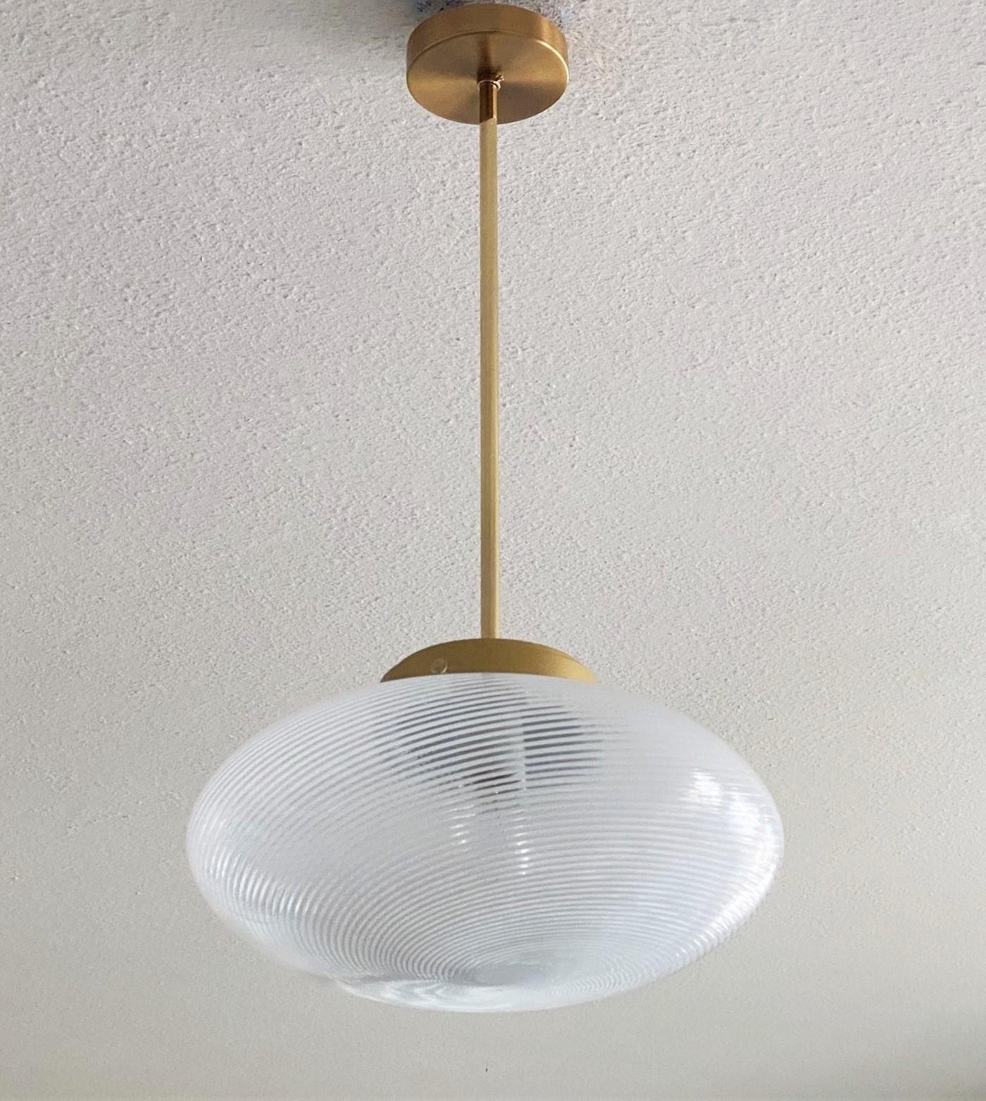 A pair of large hand blown Murano glass pendants by Ludovico Diaz de Santillana for Venini, Pendant Series -Tessuto-, Italy, 1960s. Brass and parcel gold enameled metal mounted.
Each pendant takes one E27 large sized bulb up to 100Watt. Both