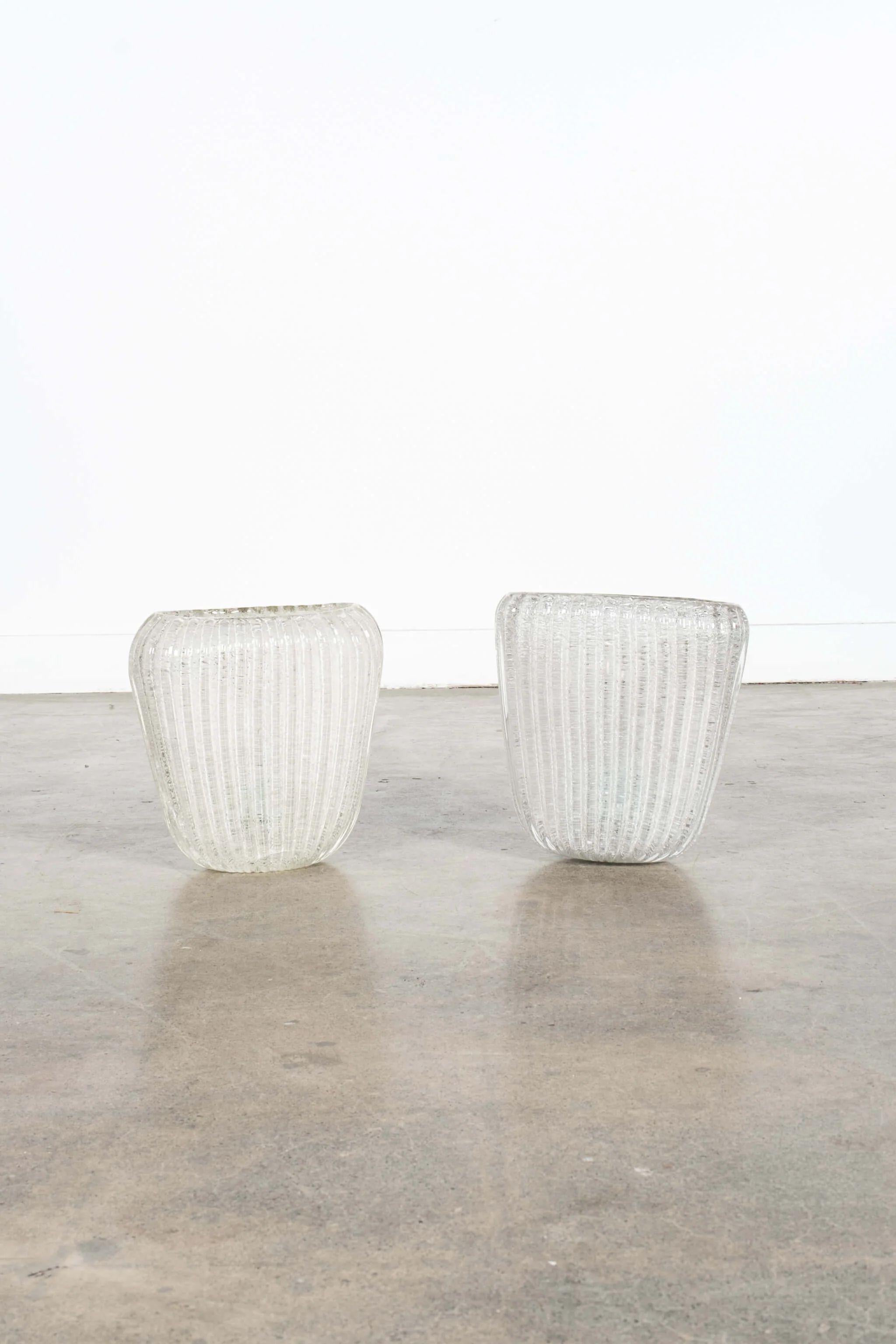 The heavy and ribbed Murano glass on the pair of sconces make them a welcome addition to any space, whether traditional or contemporary. Neutral in their shape and tone, their materiality provides just the right amount of interest and weight to a