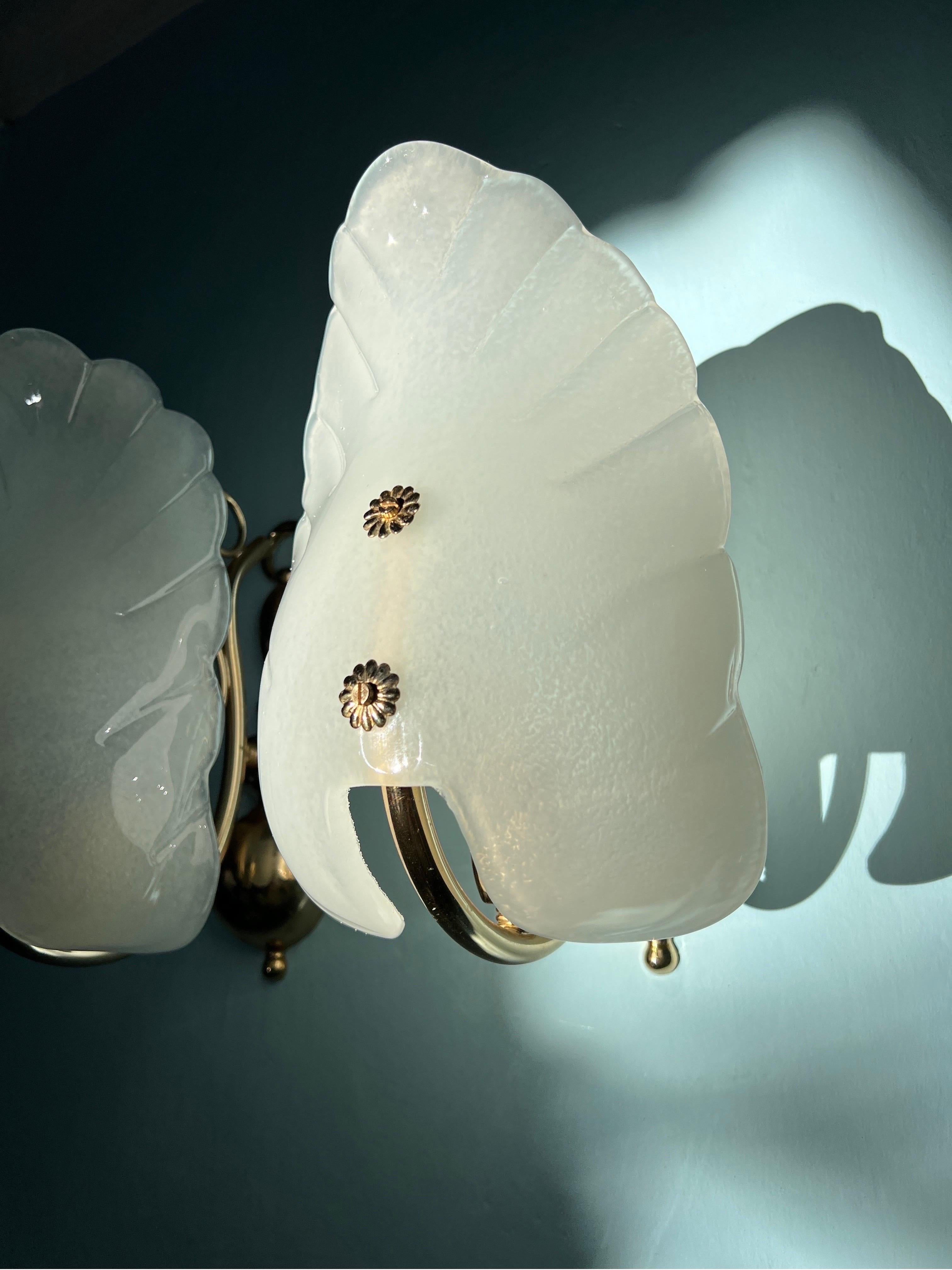 This pair of Murano glass wall lights is truly amazing. Crafted with precision, the Murano glasses is gracefully shaped like delicate shells, adding a touch of nature's elegance to their design.
The glass is set on a sturdy metal base, these