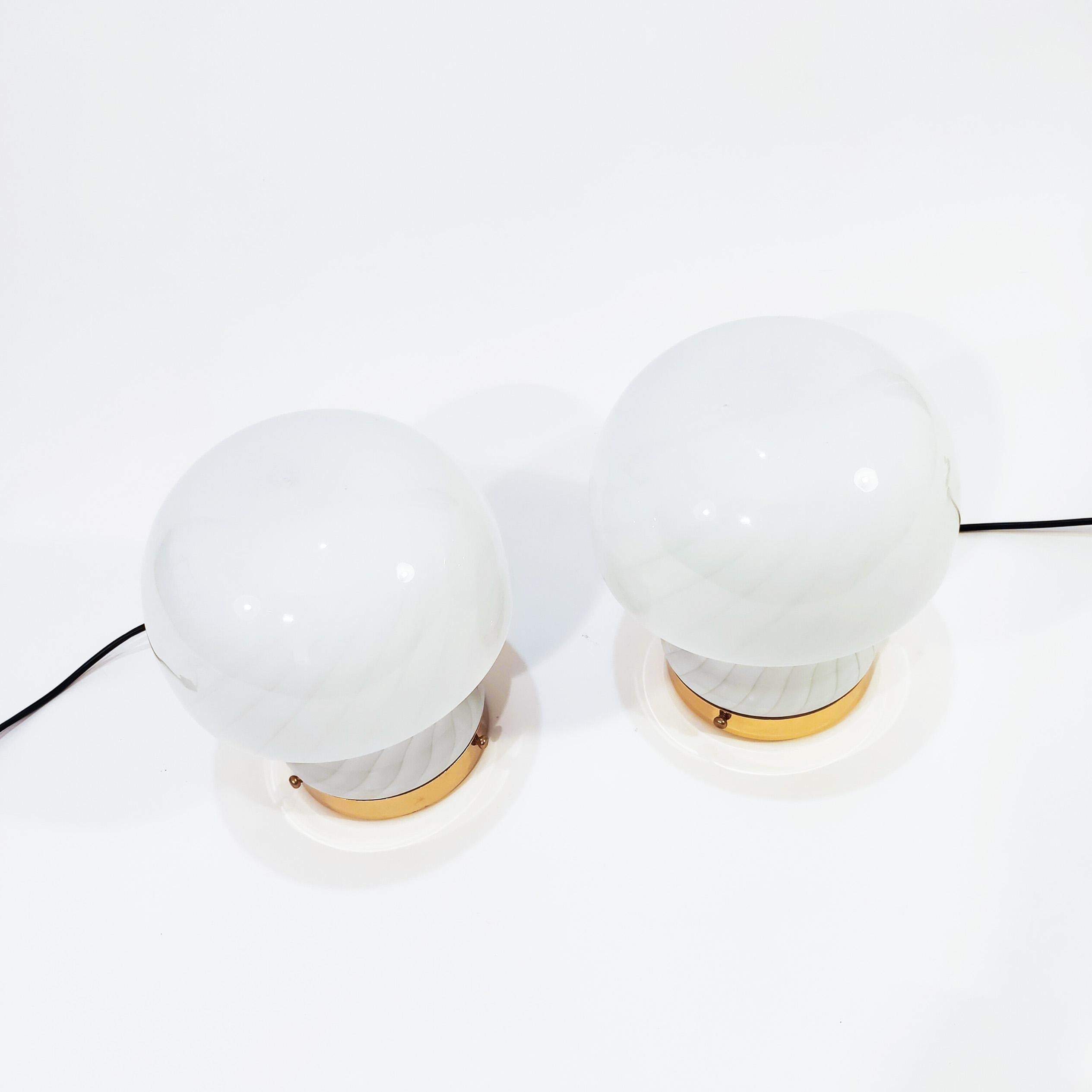 Pair of Italian table lamps from the 70s, in the style of manufacture and design by F. Fabbian. Murano glass body in the shape of a mushroom contrasting the raw white and the semi-transparent swirl-shaped. Gold chrome metal base. Very much in the