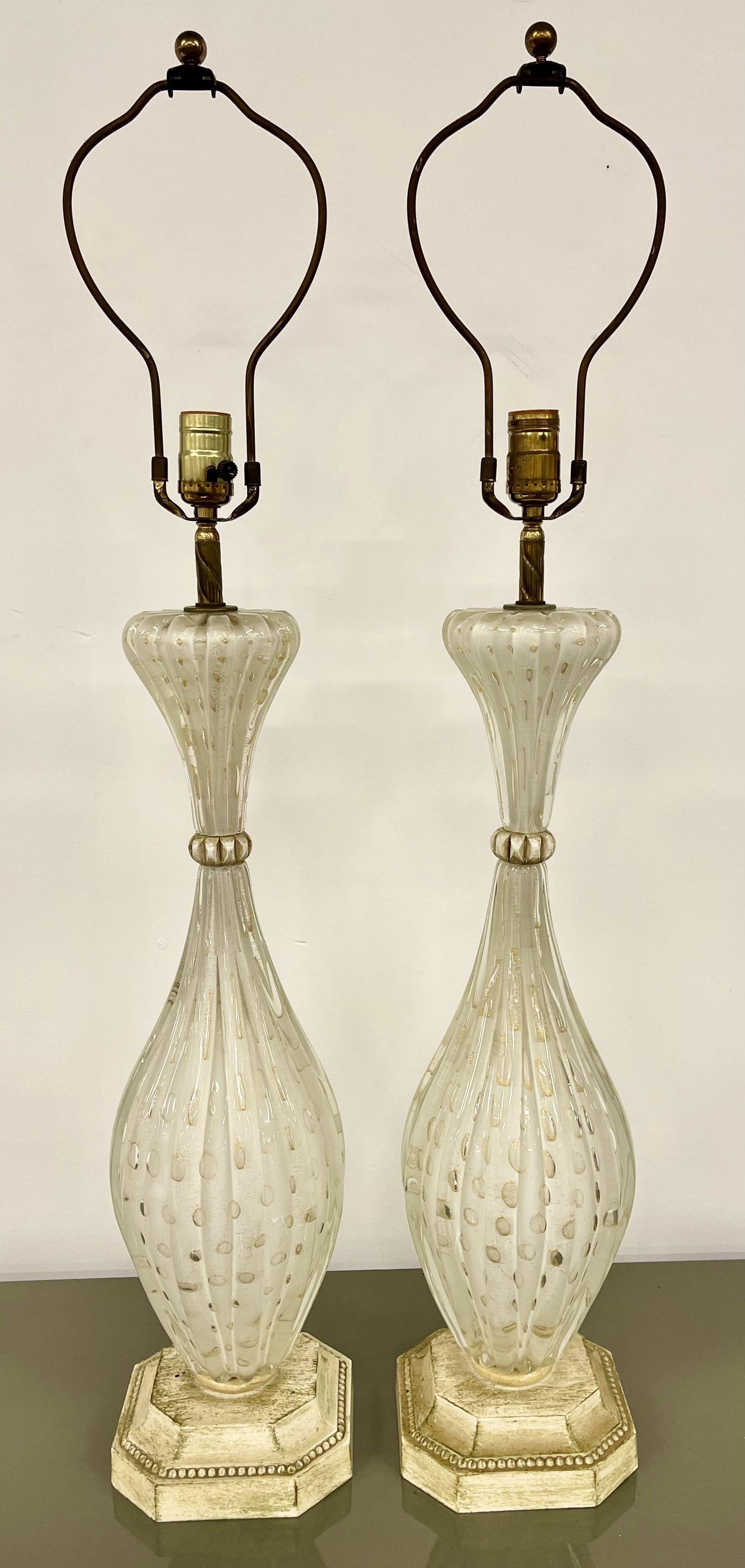 Pair of Murano Glass Speckle Table Lamps. A fine pair of  Mid Century Modern table lamps having white and clear bulbous form with speckles of gold on white distressed bases. Lamps come without shades. Each lamp takes one bulb.