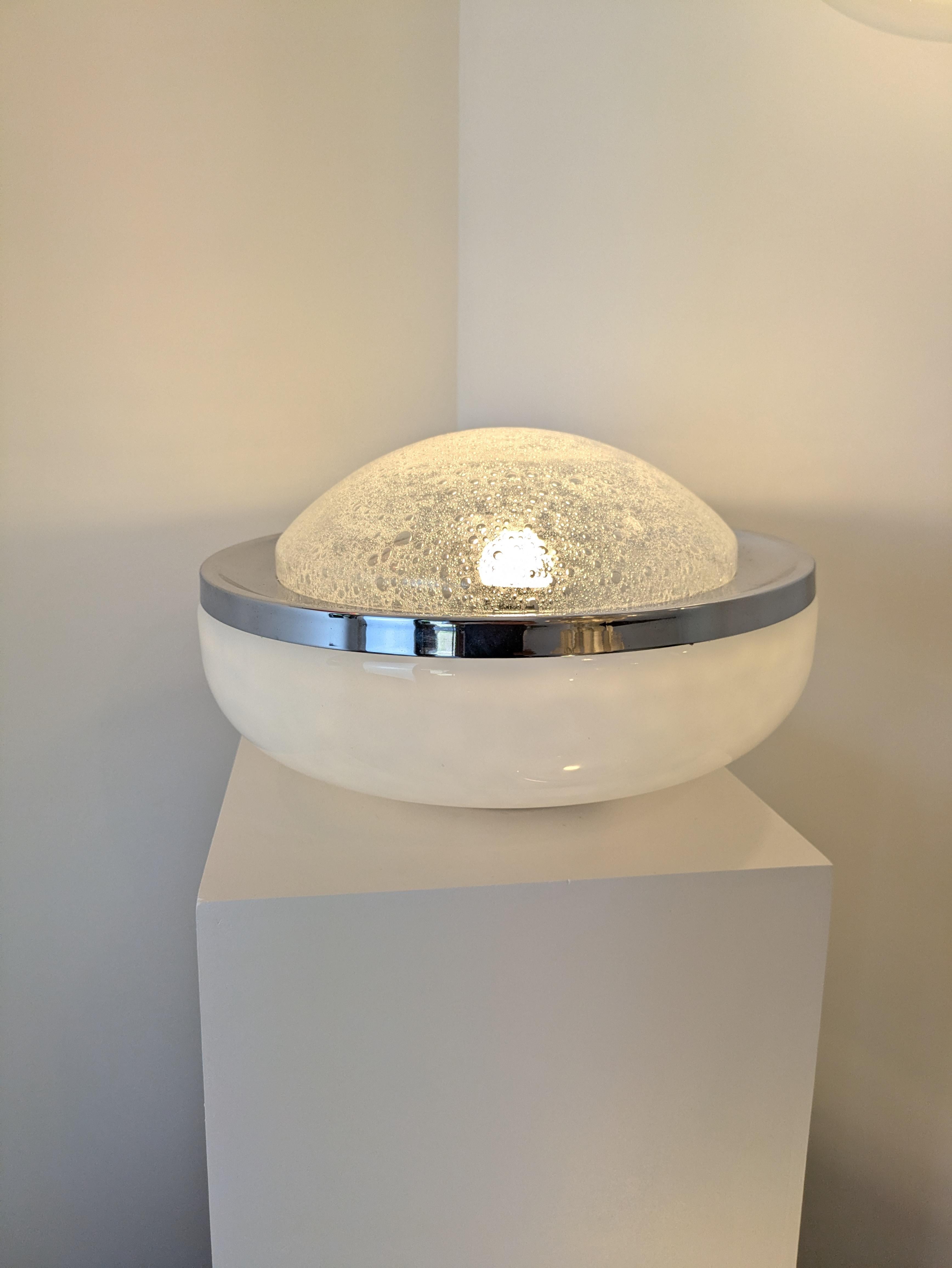 Pair of table lamps constituted of 2 assembled blown glass globes. 
The center piece is in clear glass and has bubbles on the inside, we call it 