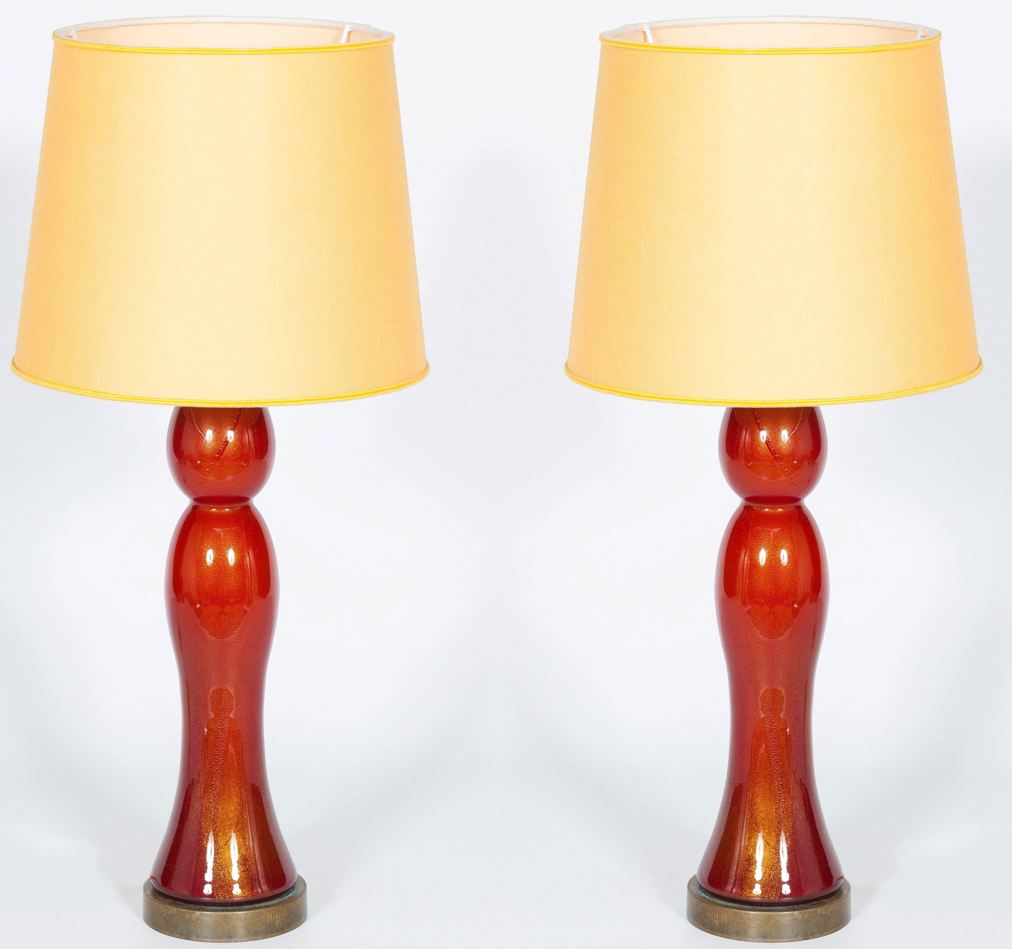 Pair of gorgeous Venetian table lamps in blown Murano glass, coral color with 24-karat sunken gold.
These lamps have been entirely handcrafted in Murano, the Venetian island, in the 1980s. They curvy and delicate shapes give a fine touch of