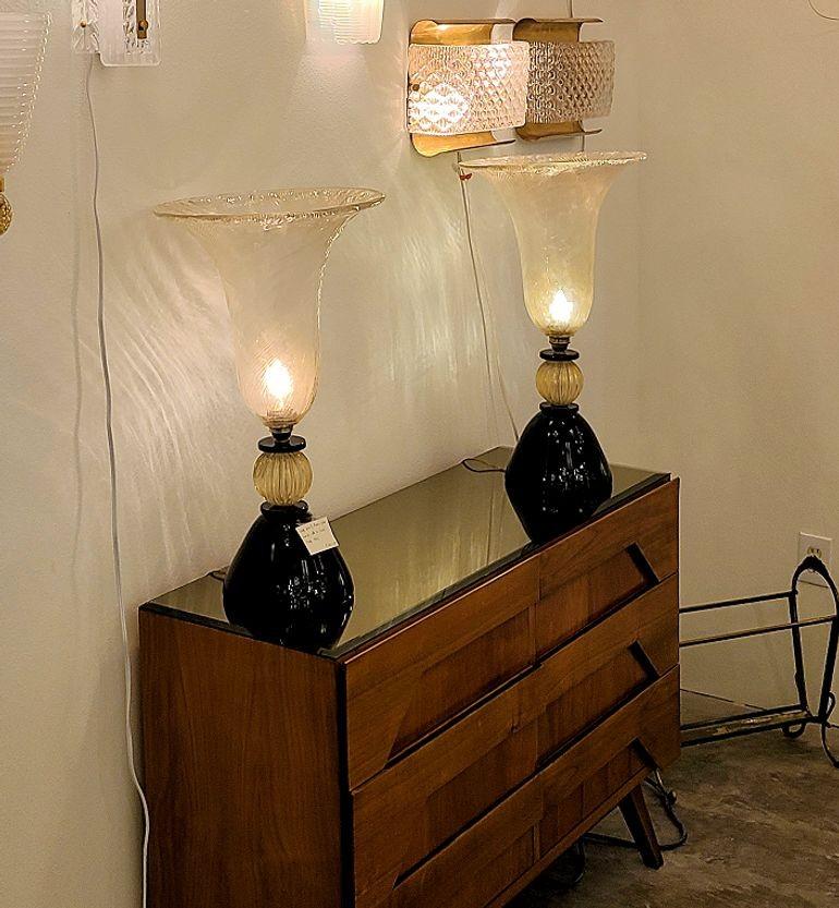 Pair of large Mid-Century Modern Murano glass table lamps, Venini style and quality. Italy 1960s.
The neoclassical style lamps are entirely made of Murano glass: a black opaque Murano glass base and a large clear with gold inclusions top vase,