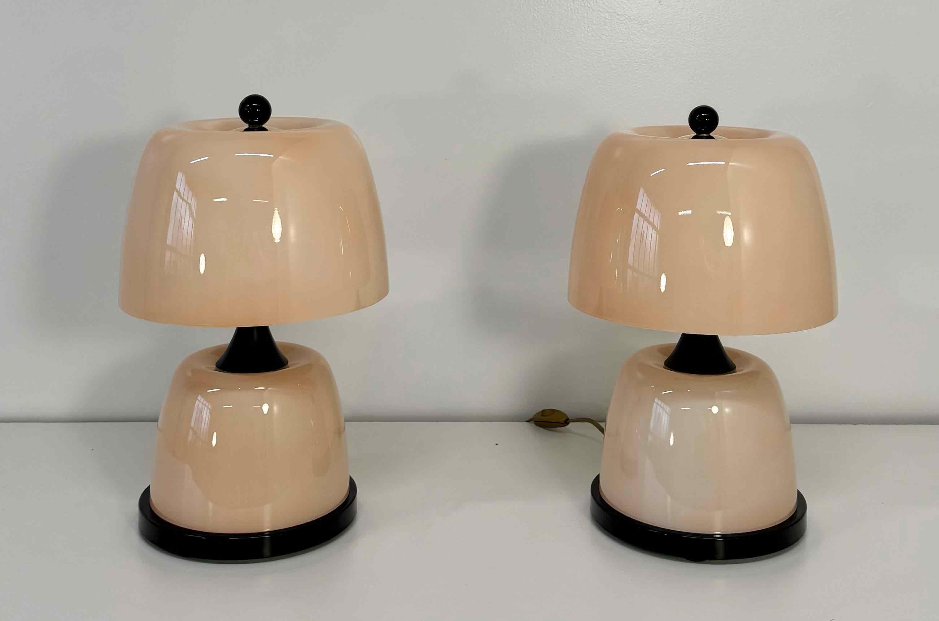 Elégante paire de lampes de table en verre de Murano fabriquées à la main en Italie dans les années 2000.
Chaque lampe présente un corps en verre rose raffiné avec des détails noirs, entièrement réalisé par des verriers qualifiés de Murano.
Le