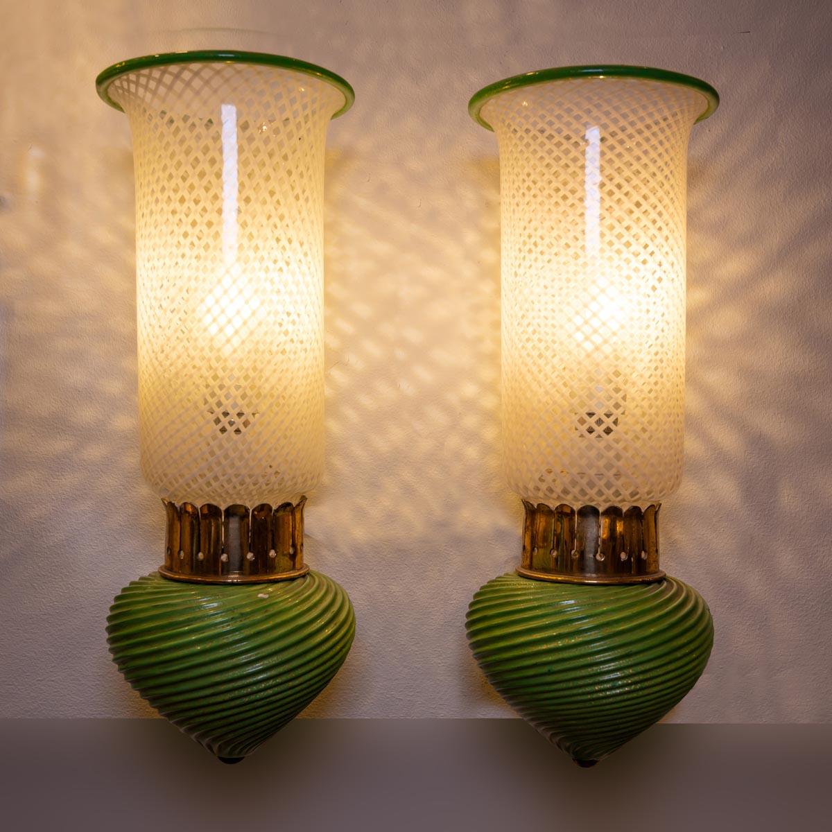 Pair of 1930s Murano wall lights featuring clear, white, and green glass on a brass base. 

Created in Murano in the 1930s-1940s, the design is often associated with Venini Murano. The lights showcase a mix of blown glass techniques, including paste