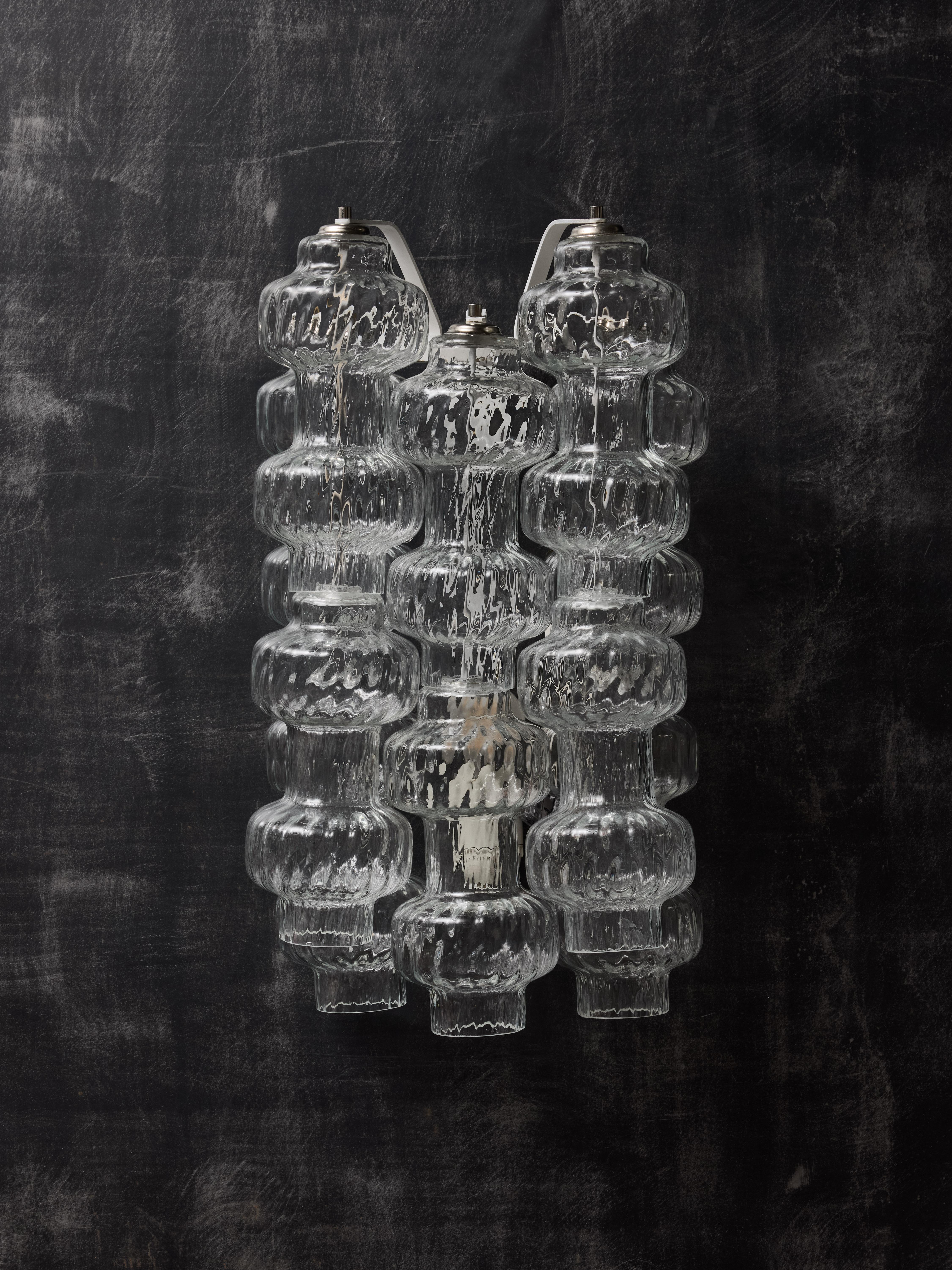 Pair of wall sconces made of a painted metal structure from which hangs five stacks of two Murano glass blown pieces. One source of light per sconce.

CARLO SCARPA (1906 – 1978)

Carlo Scarpa was an Italian architect and designer who drew