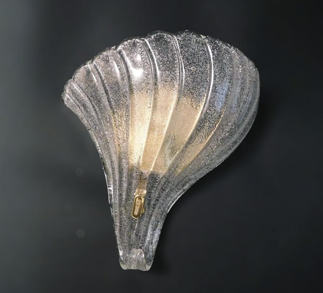 Applique italiana con scudo in vetro di Murano soffiato a mano con la tecnica Graniglia per ottenere un effetto granulare, montata su una cornice dorata / Made in Italy da F. Fabbian, circa anni '70
Adesivo e marchio originale sul telaio
Misure: