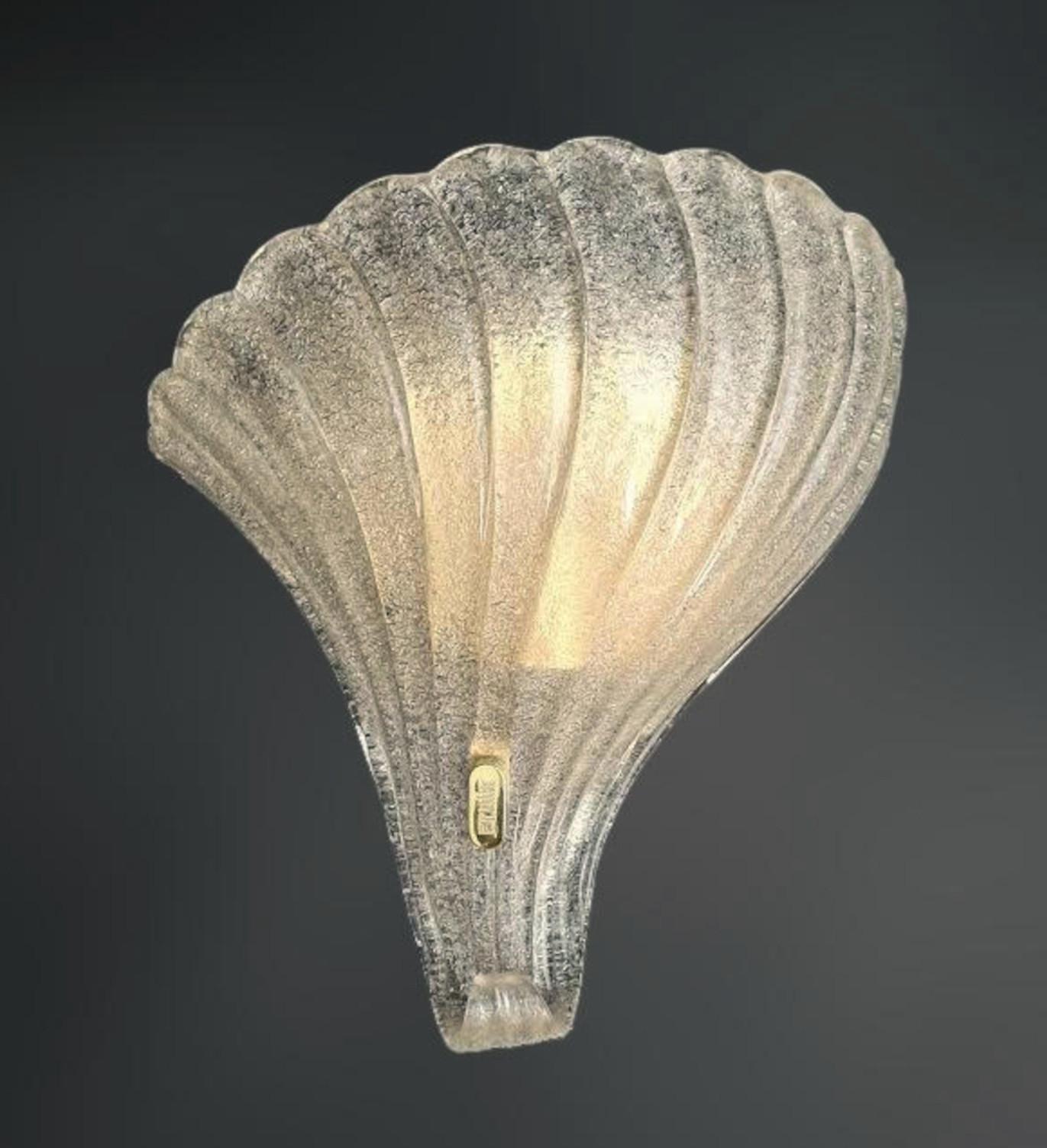 Italian wall light with a Murano glass shield hand blown in Graniglia technique to produce granular textured effect, mounted on gold frame / Made in Italy by F. Fabbian, circa 1970s
Original mark on the frame
Measures: Height 12 inches, width 12.5