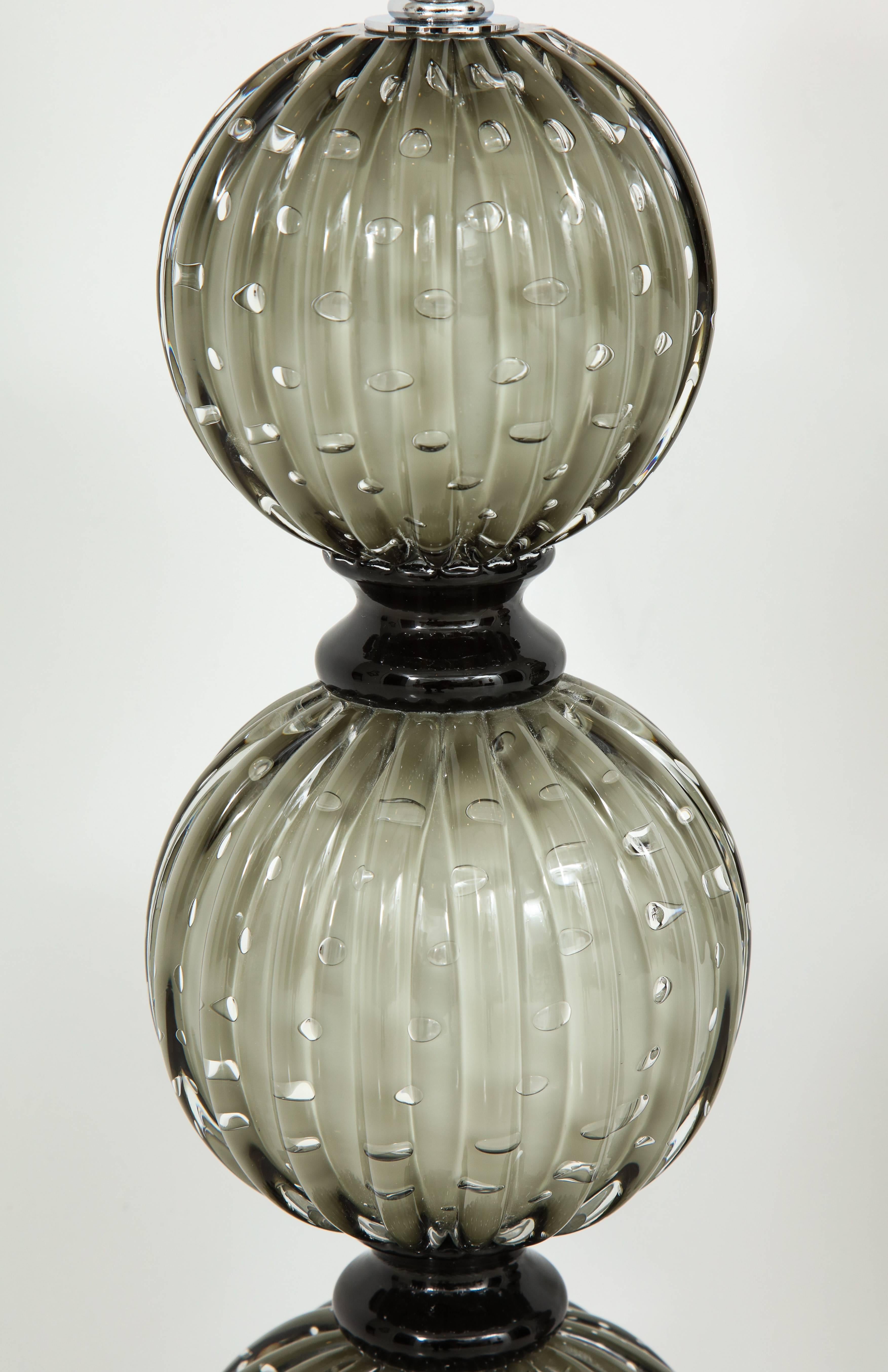 Pair of heavy Murano glass table lamps in the style of Barovier. The glass color is a soft grey over an ivory underlay with clear bubbles inside glass layer creating a gorgeous look and texture. Each of the three glass spheres is divided by a dark