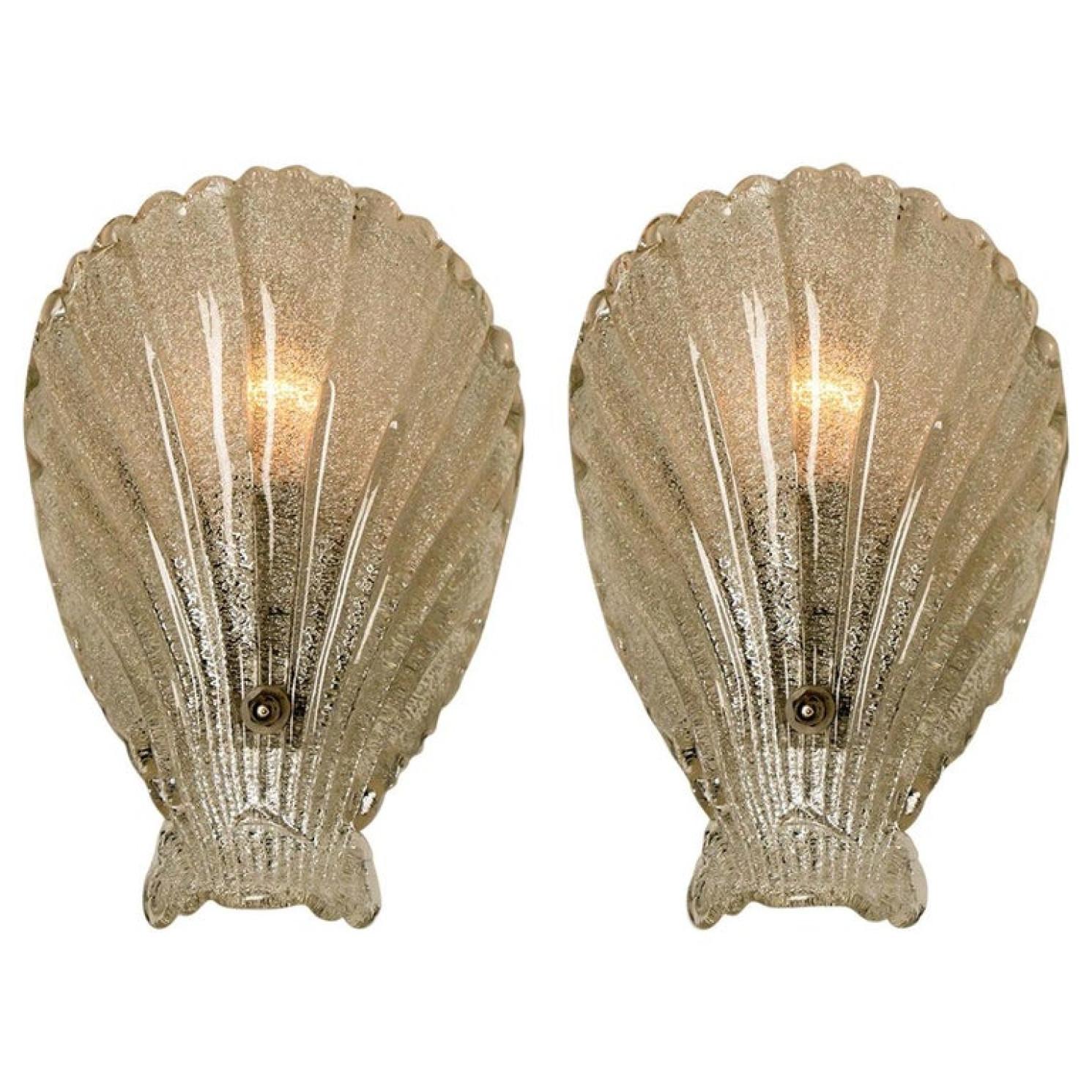 Pair of sea shell form wall lights, produced in Italy, in textured glass, affixed against a chrome base, circa 1960s.
An iconic design from the 1960s and still relevant today.

Good condition, consistent with age and use. Each light requires one E14
