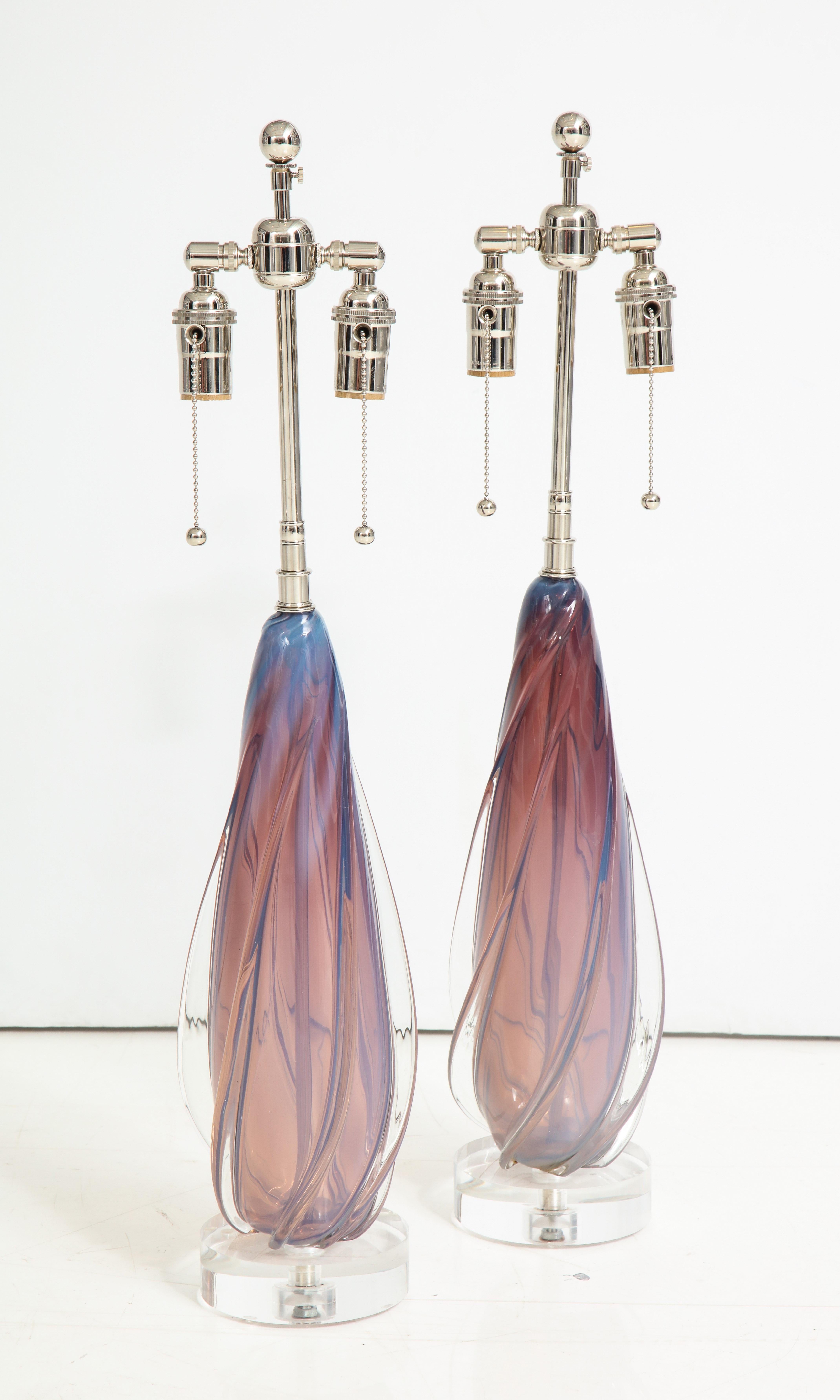Exquisite pair of Murano lamps By Seguso.
The handblown glass lamp bodies have wonderful mauve, pink and gray tones and are mounted on thick Lucite bases. They have been newly rewired for the US with polished nickel double clusters that take