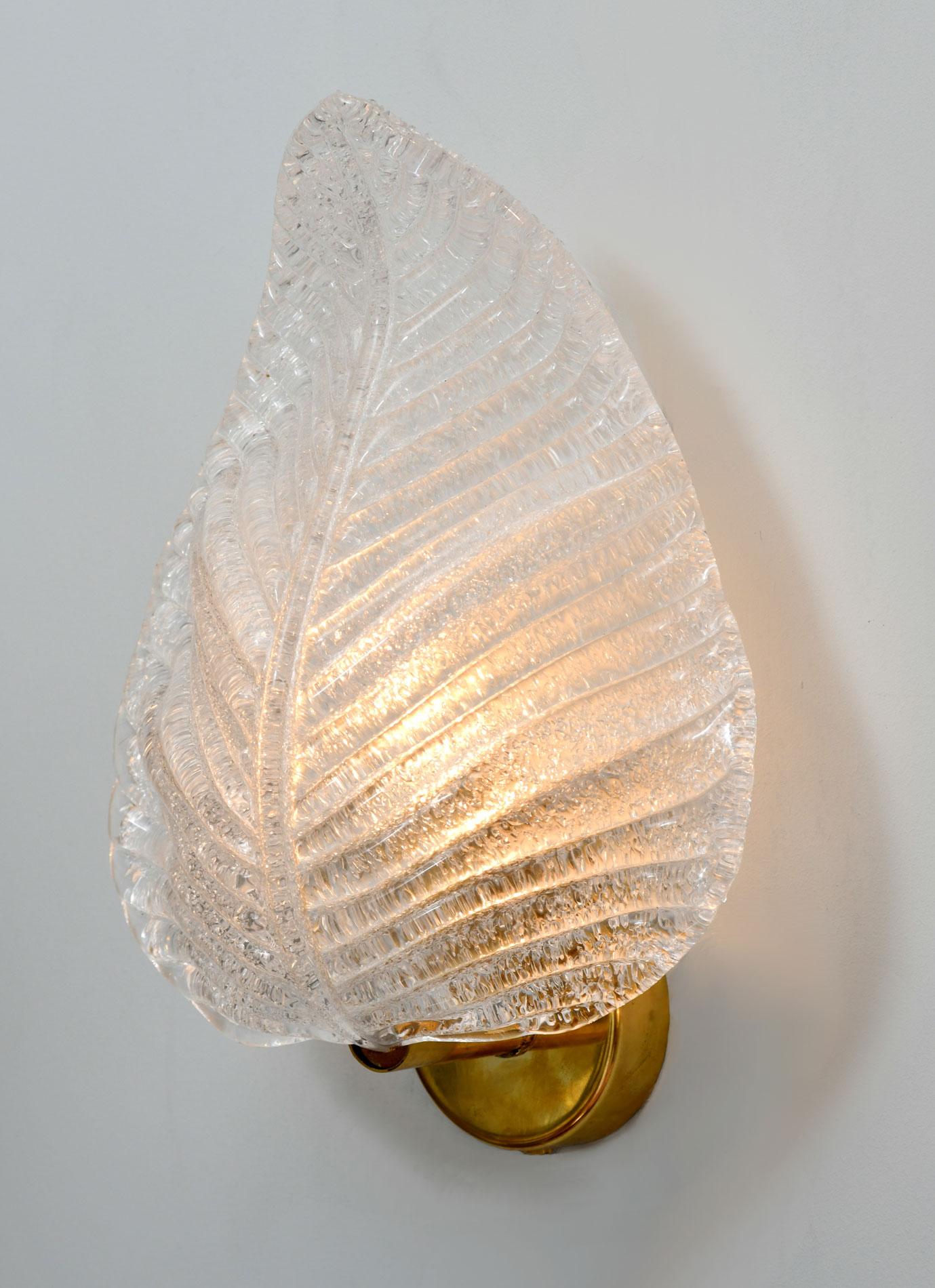 Thick frosted Murano glass sculpted and textured into a leaf. Sits on a circular brass wall fitting. Emits lovely warm light.